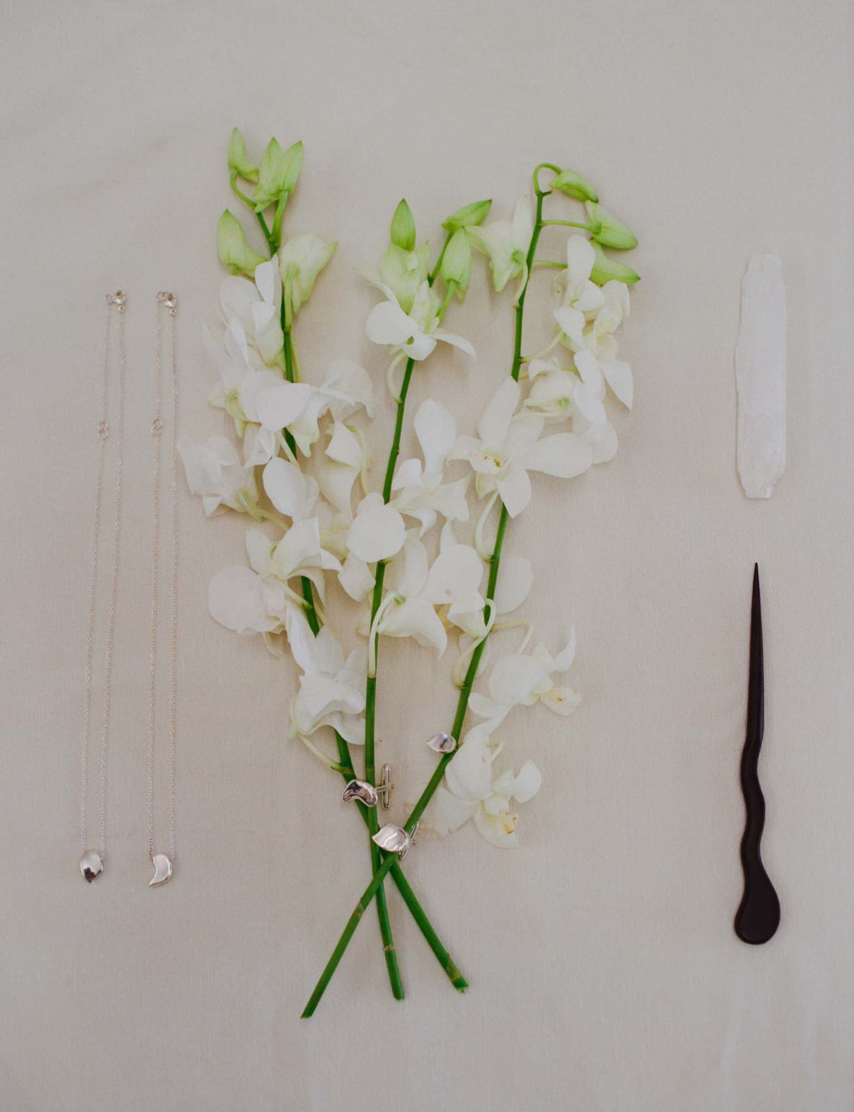 AGMES .925 sterling silver sculptural sum of parts heart pendant necklaces, mini brooch and stud earrings. Whotographed with white flowers, wooden hair pin, and white stone.