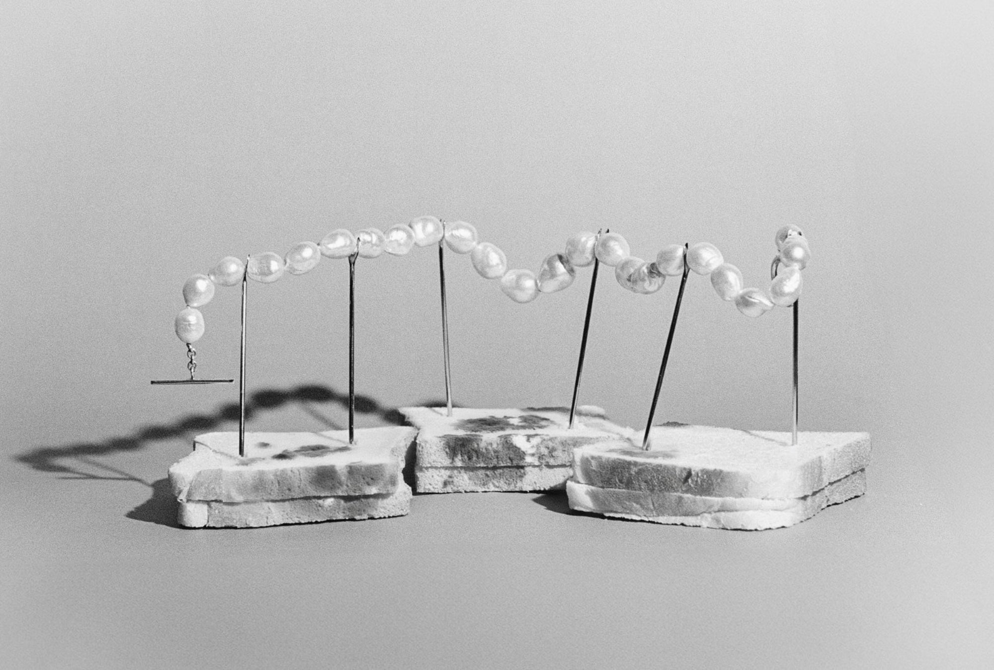 AGMES .925 sterling silver and freshwater pearl Baroque Pearl Necklace held up by silver pins. Black and white image.