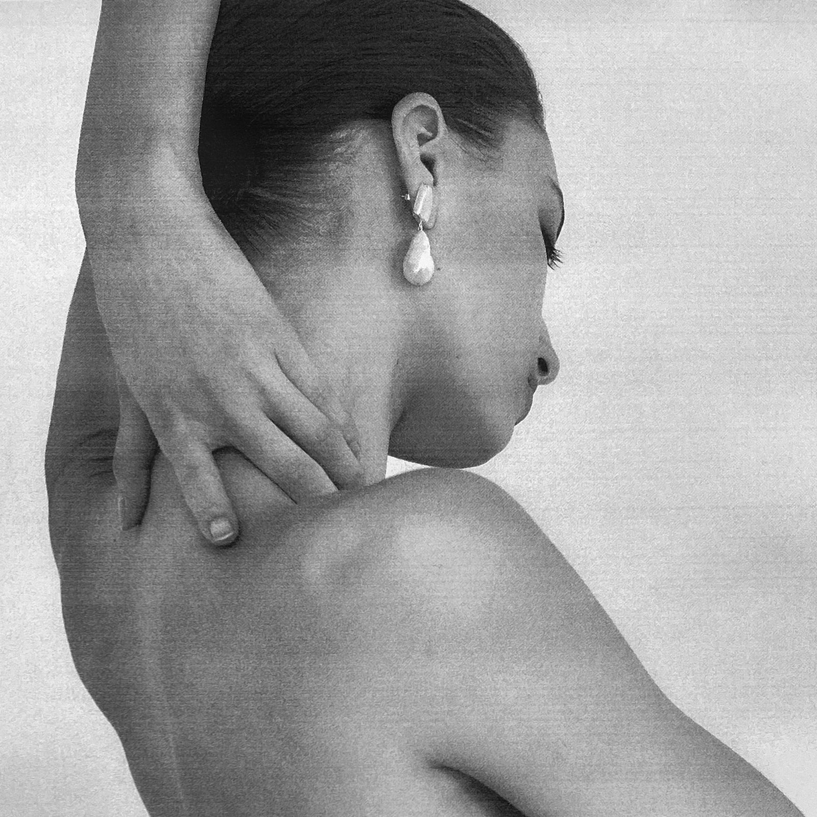 Woman wearing AGMES 0.925 sterling silver square shaped earrings with large baroque freshwater pearl drop.