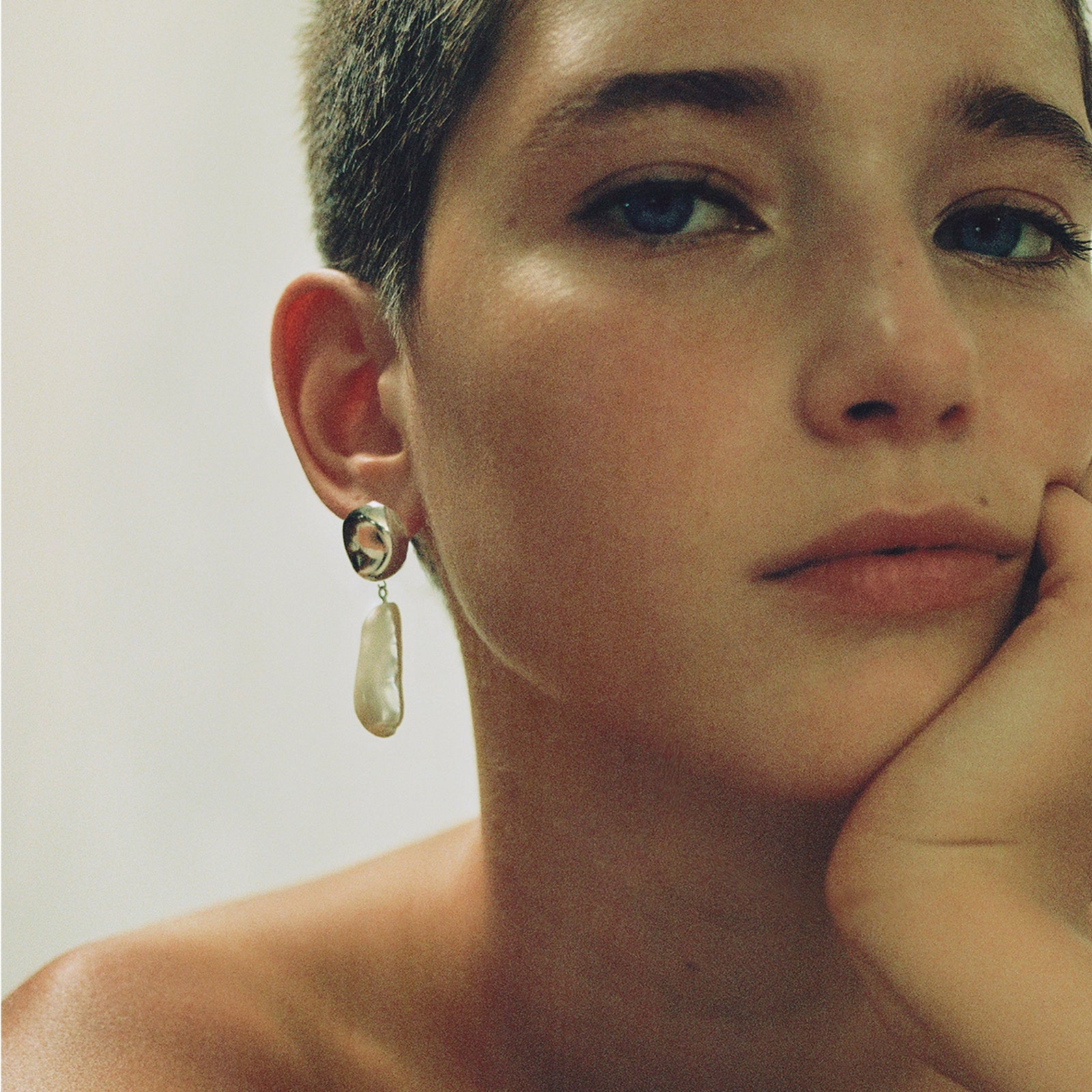 Woman wearing AGMES 0.925 sterling silver earrings with freshwater pearl drop.