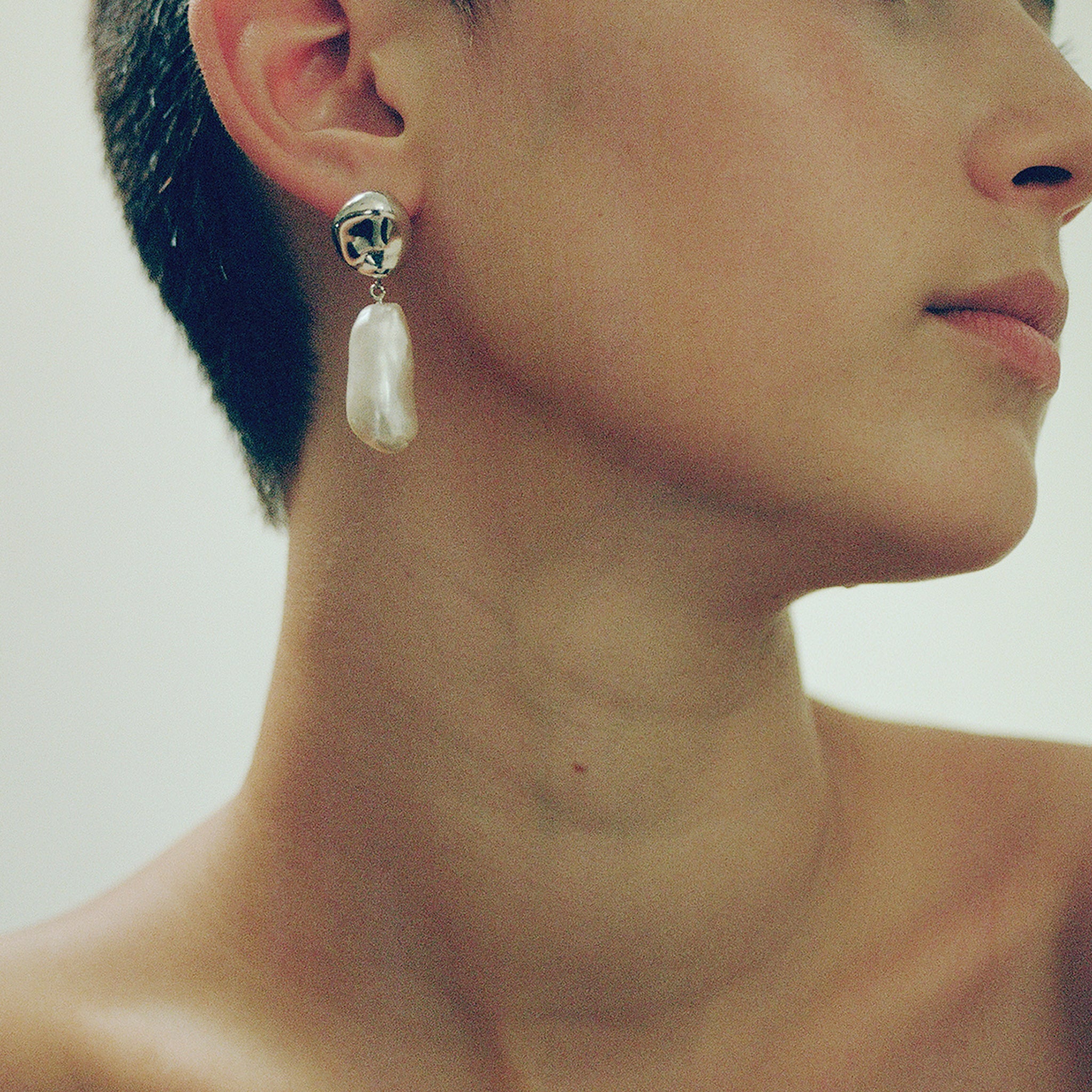 Woman wearing AGMES 0.925 sterling silver earrings with freshwater pearl drop.