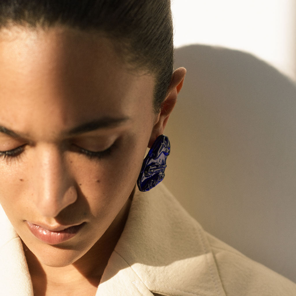 Woman wearing AGMES Handblown Venetian Glass earrings in blue.