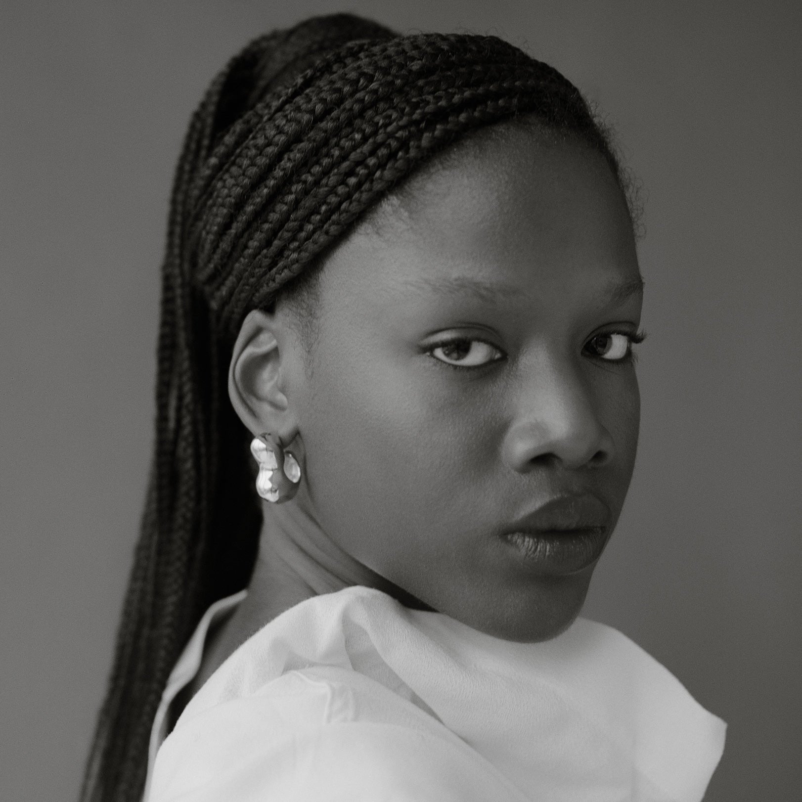 Woman wearing AGMES 0.925 sterling silver sculpted bubble hoop earrings. Simone Bodmer-Turner.