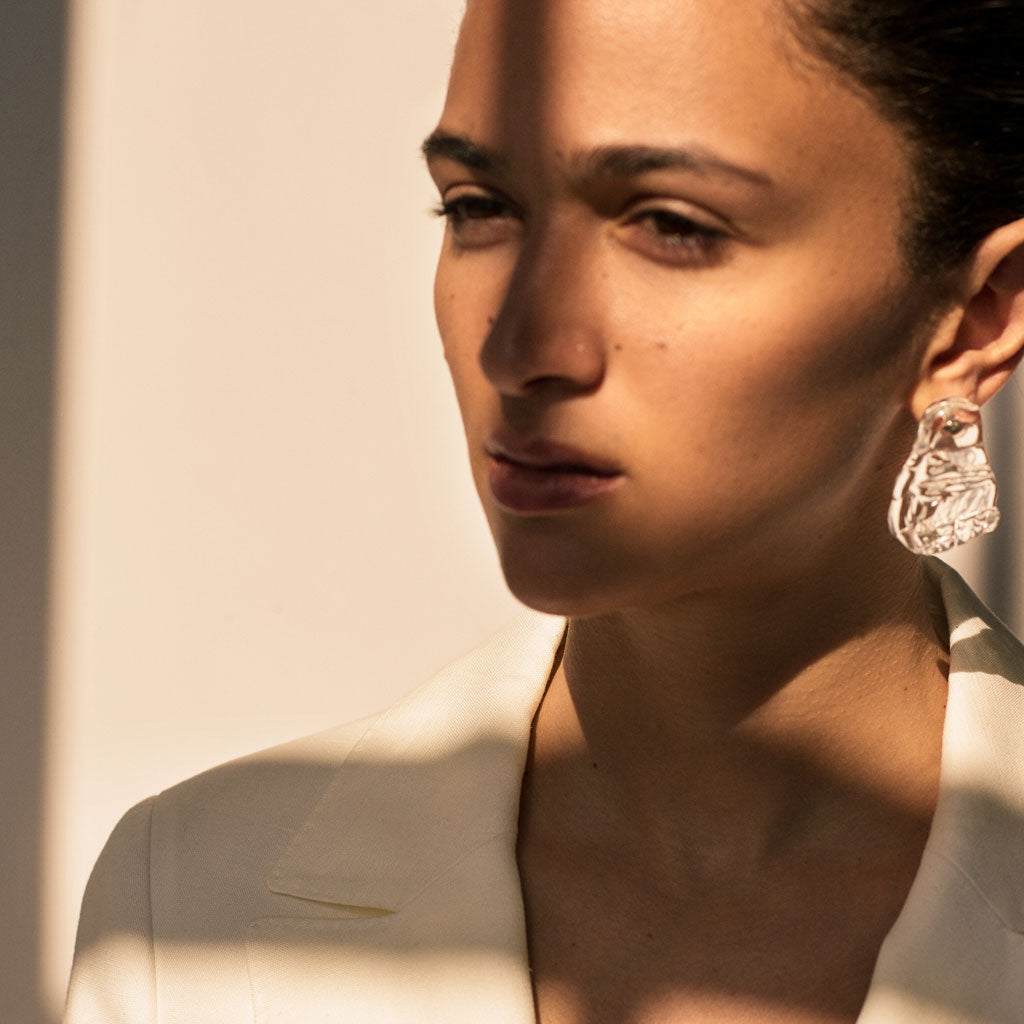 Woman wearing AGMES Handblown Venetian Glass earrings in clear.