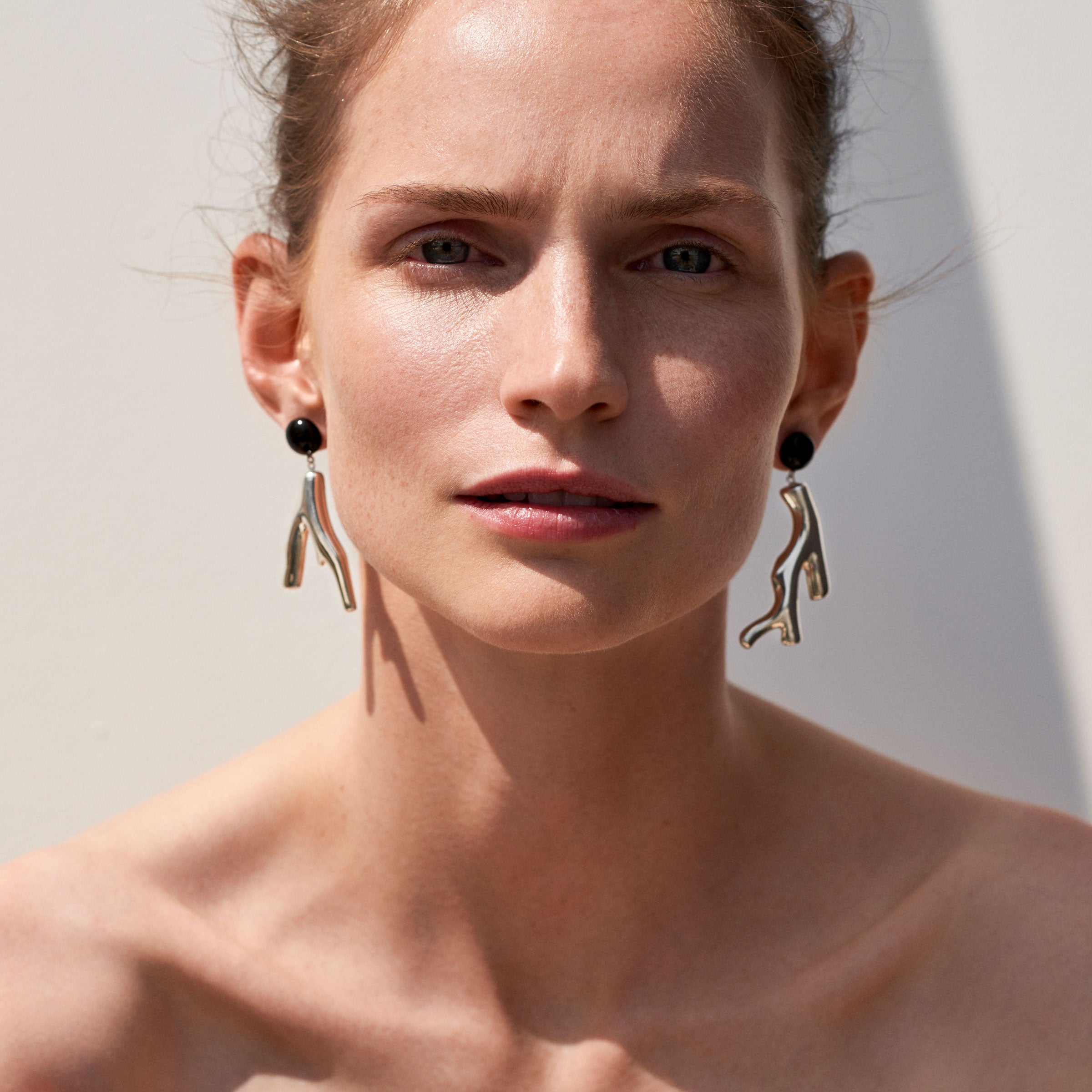 Woman wearing AGMES 0.925 sterling silver coral drop earrings with an onyx top.