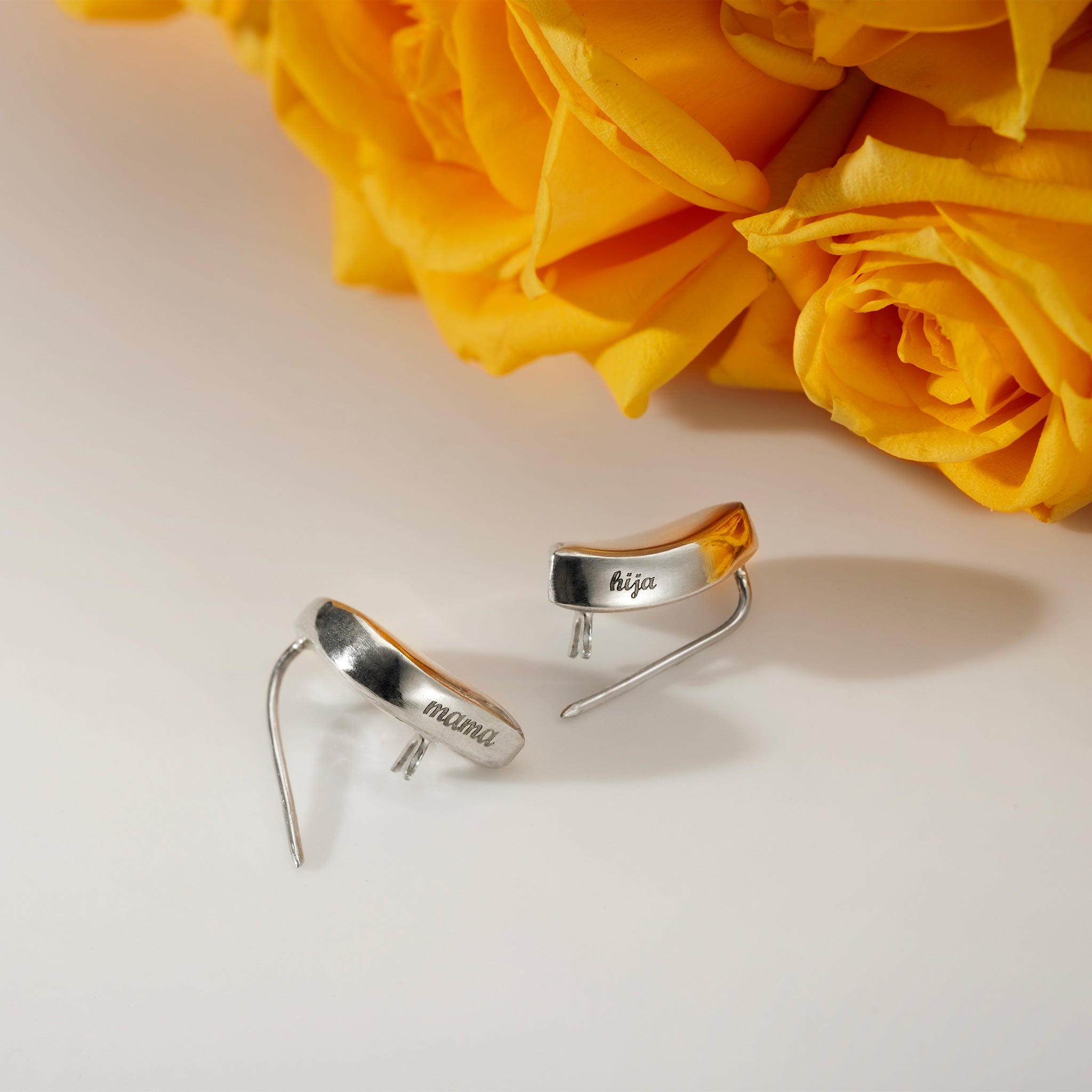 AGMES .925 Sterling Silver Sum of Parts Brooch with Custom Engravings. Set of Two. Displayed near yellow flowers.