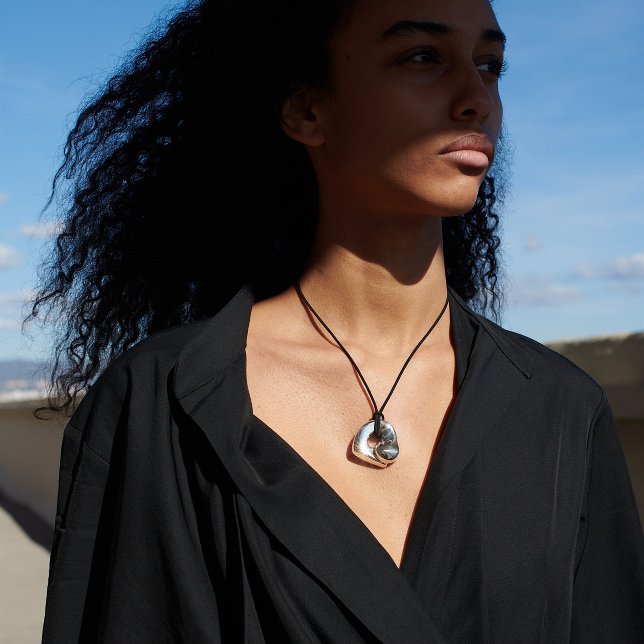 Woman wearing AGMES .925 Sterling Silver Structural Gertrude Pendant with Black Suede Cord. Simone Bodmer-Turner.