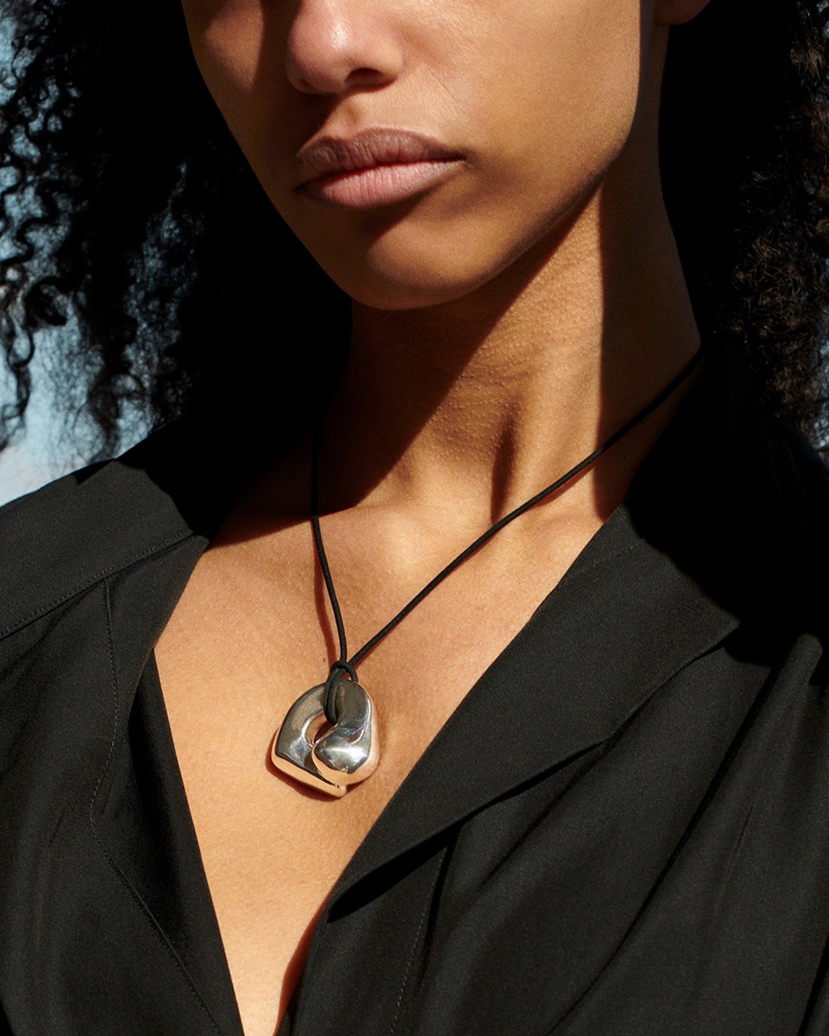 Woman wearing AGMES .925 Sterling Silver Structural Gertrude Pendant with Black Suede Cord. Simone Bodmer-Turner.