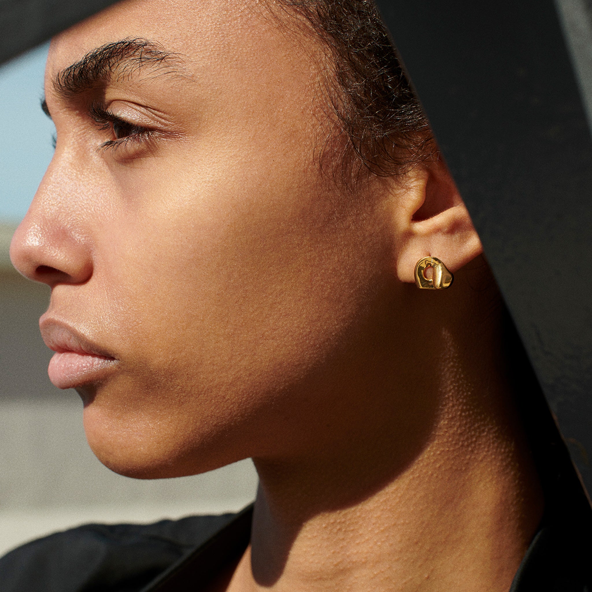 Woman wearing AGMES 18k gold vermeil sculpted Gertrude stud earrings. Simone Bodmer-Turner.