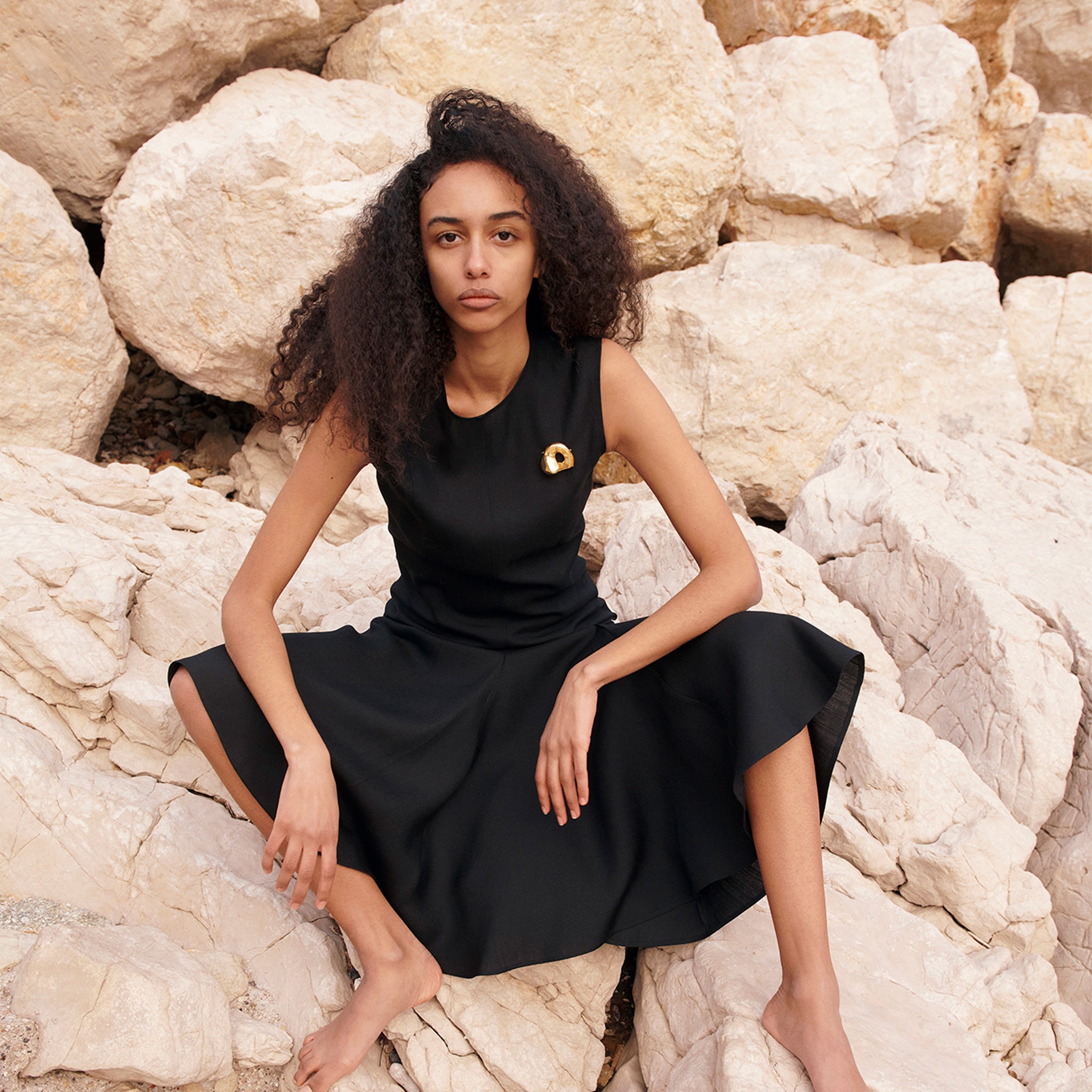 Woman wearing AGMES 18K Gold Vermeil Gertrude Brooch on black dress. Simone Bodmer-Turner.