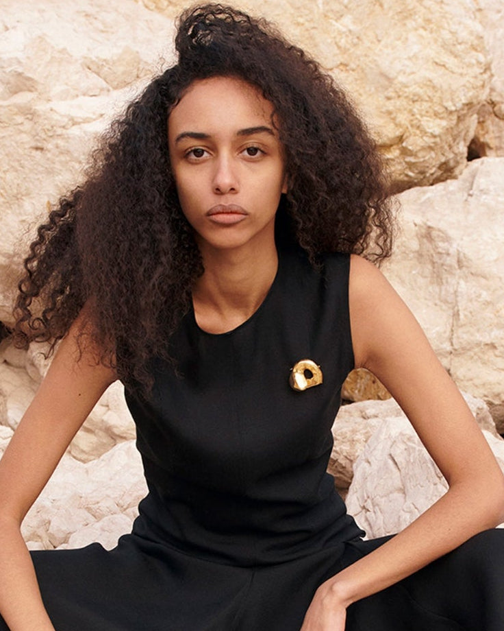 Woman wearing AGMES 18K Gold Vermeil Gertrude Brooch on black dress. Simone Bodmer-Turner.