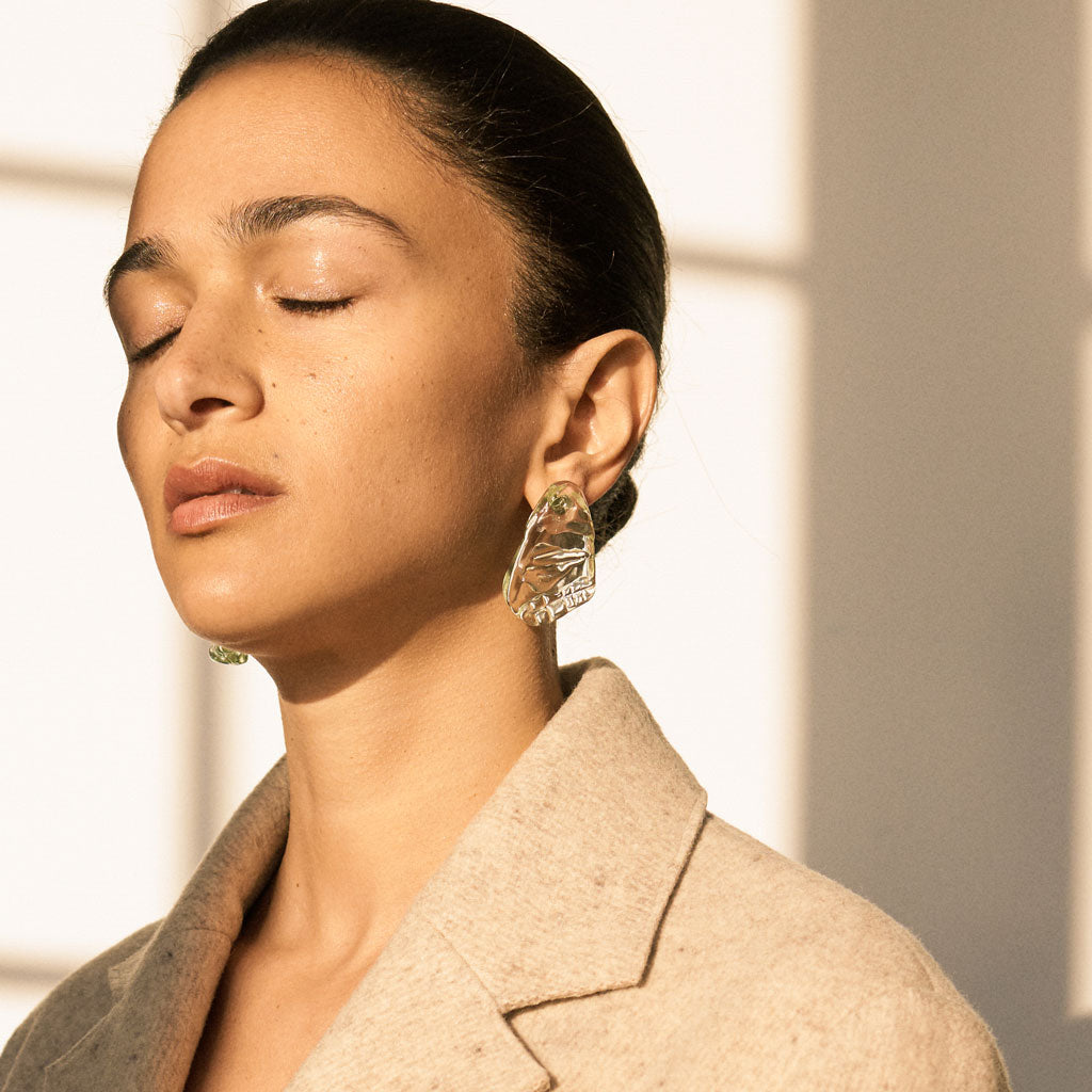 Woman wearing AGMES Handblown Venetian Glass earrings in green.
