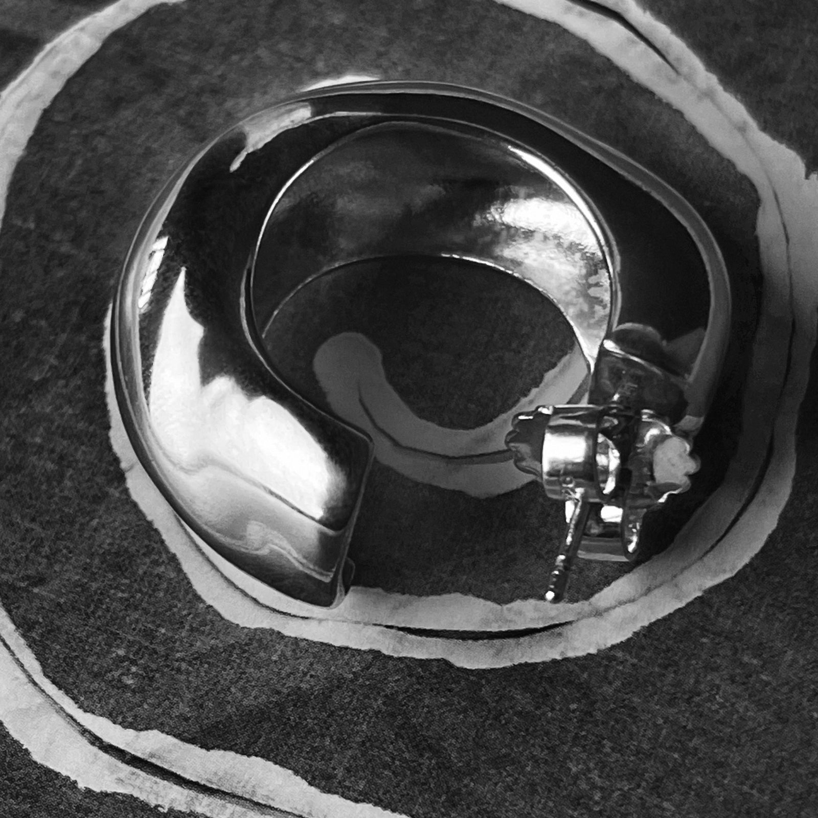 AGMES .925 sterling silver sculptural Large Celia Hoops on fabric background. Black and white image.