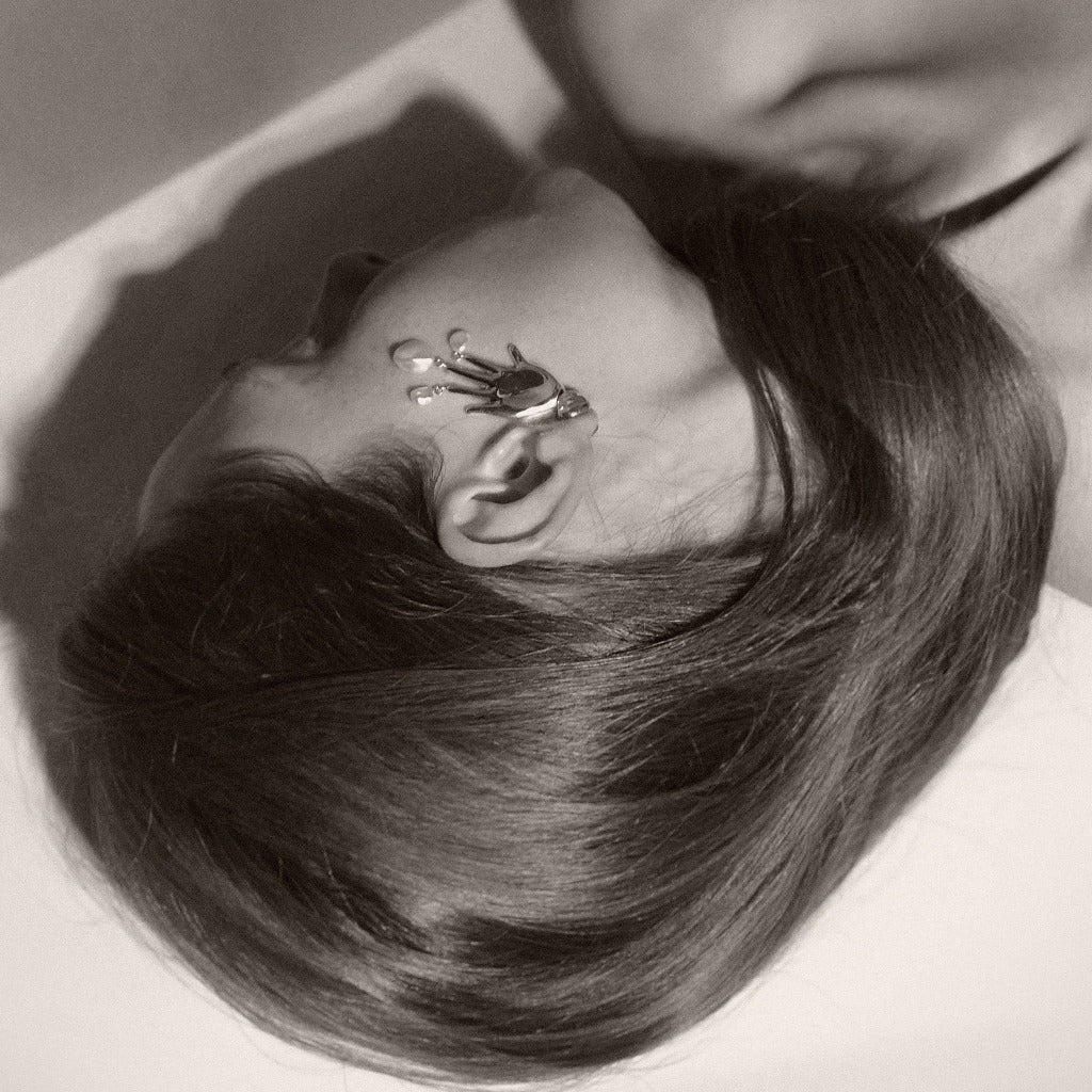 Woman wearing AGMES 18k gold vermeil hand shaped Lee earrings with freshwater pearl drops.