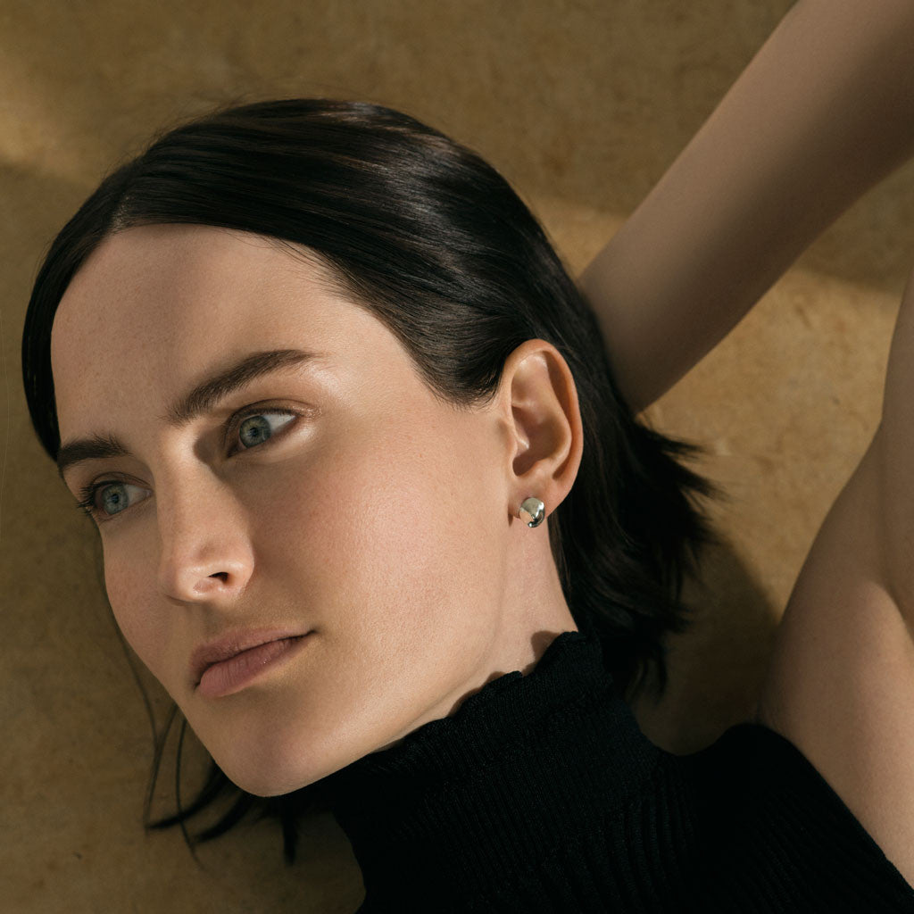 Woman wearing AGMES 0.925 sterling silver round stud earrings.