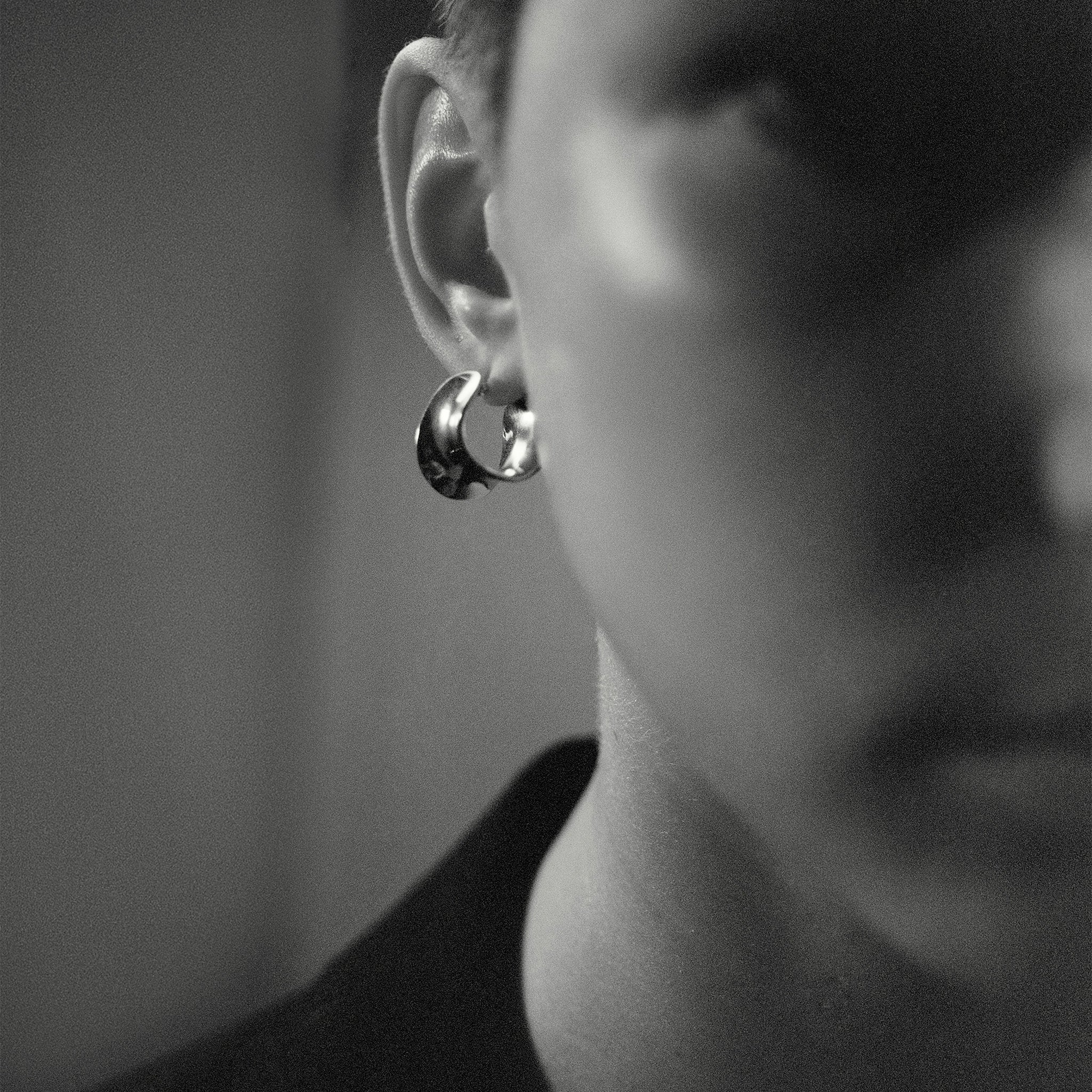 Person wearing AGMES 0.925 sterling silver mini twist hoop earrings.