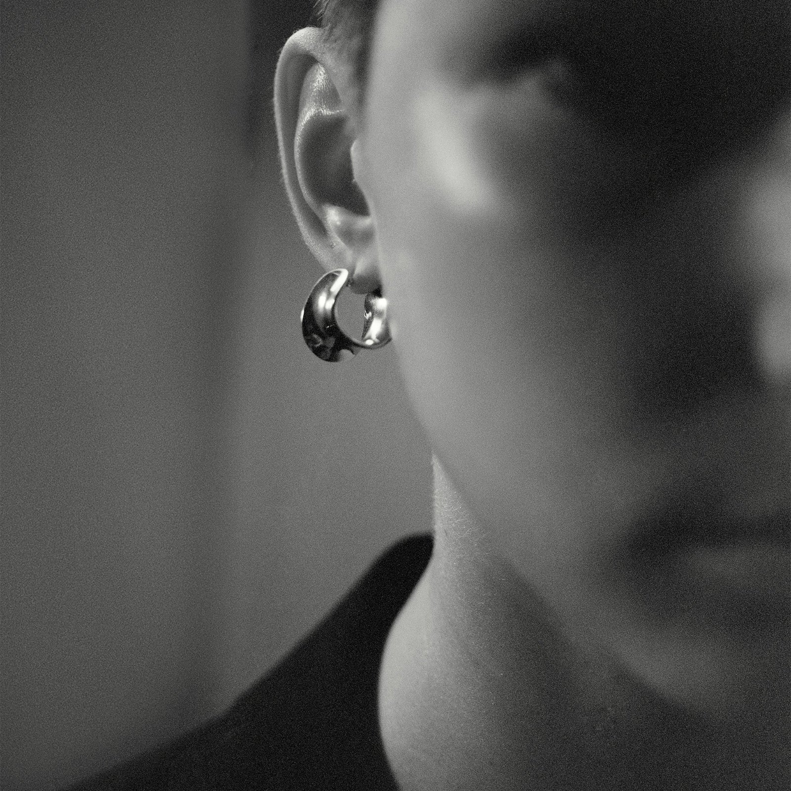 Person wearing AGMES 0.925 sterling silver mini twist hoop earrings.