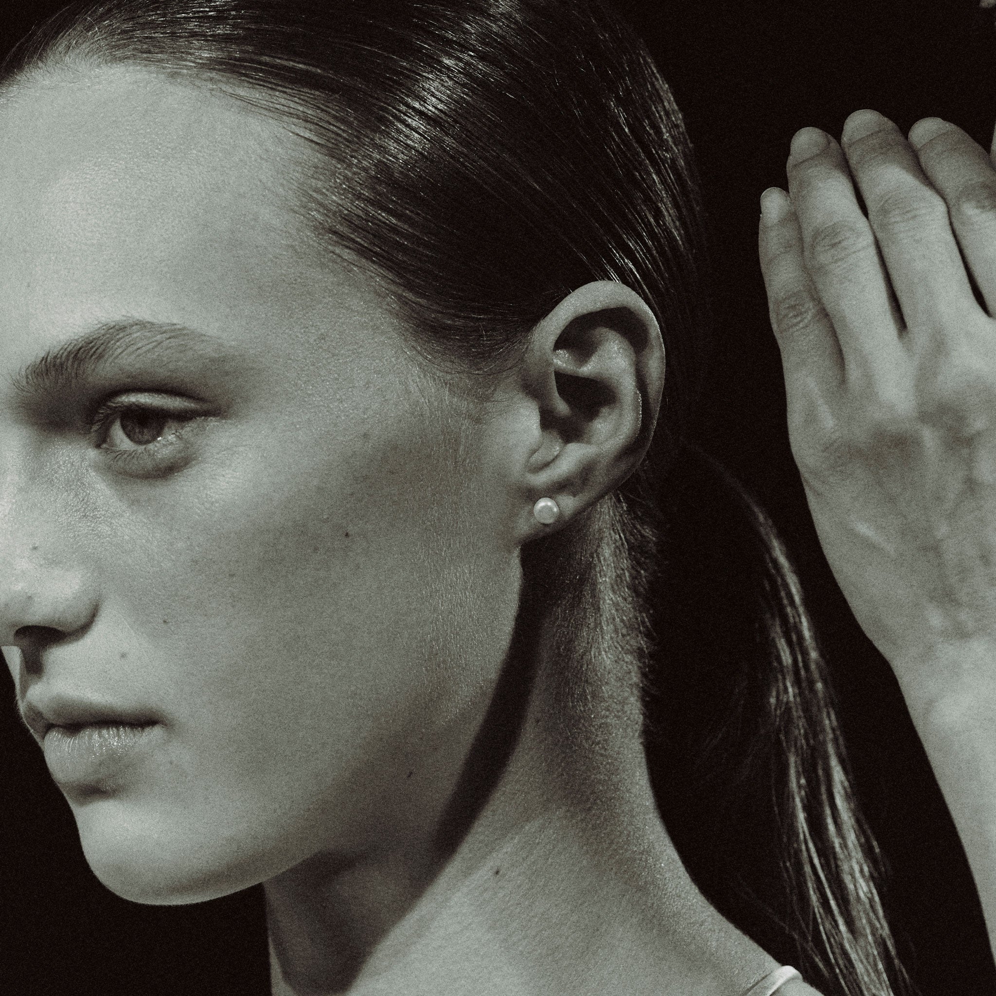 Woman wearing AGMES pearl stud earrings.