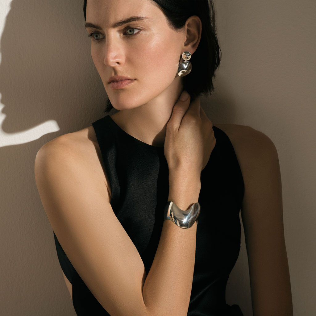 Woman wearing AGMES 0.925 sterling silver short circular round drop earrings.