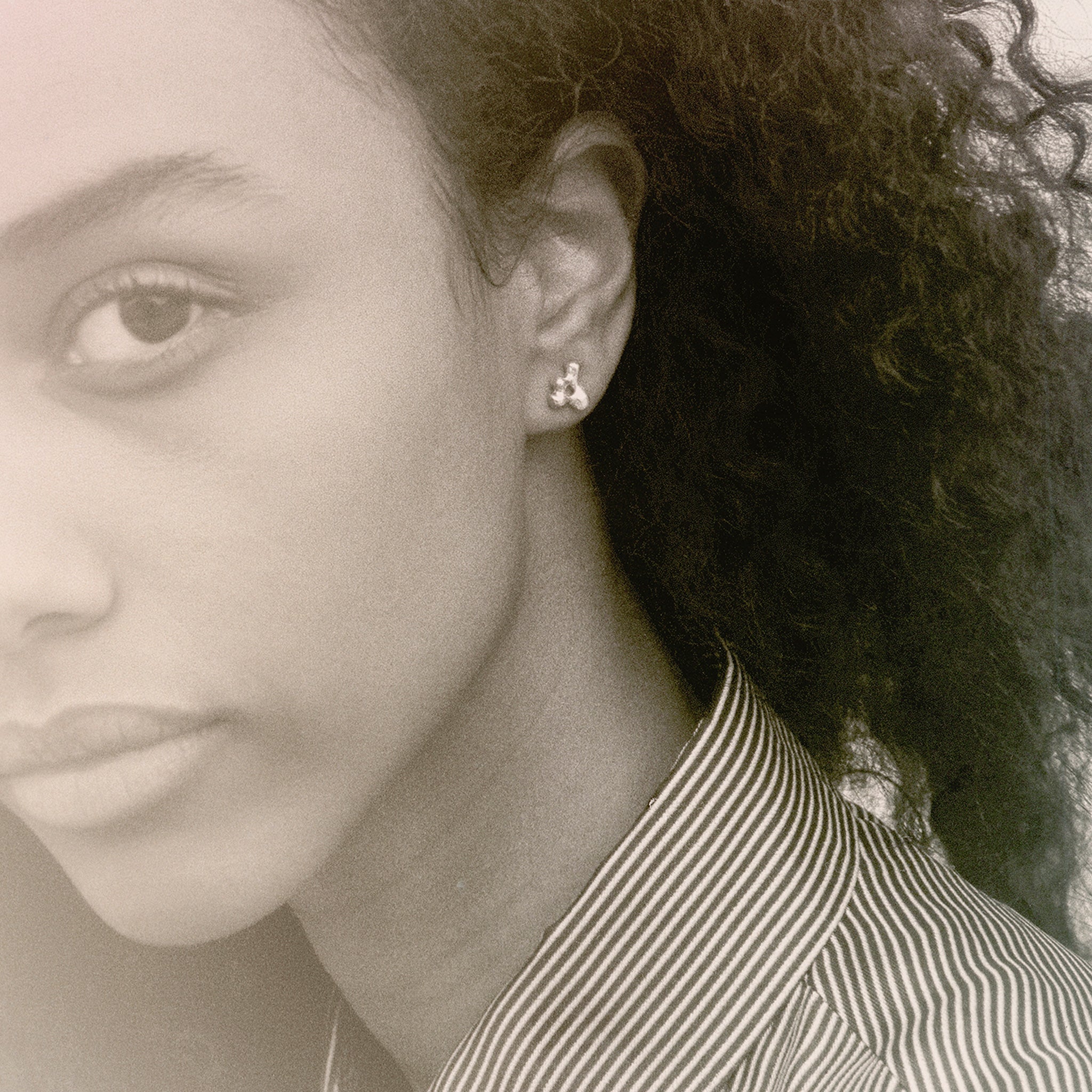 Woman wearing AGMES 0.925 sterling silver sculpted mini stud earrings. Simone Bodmer-Turner.