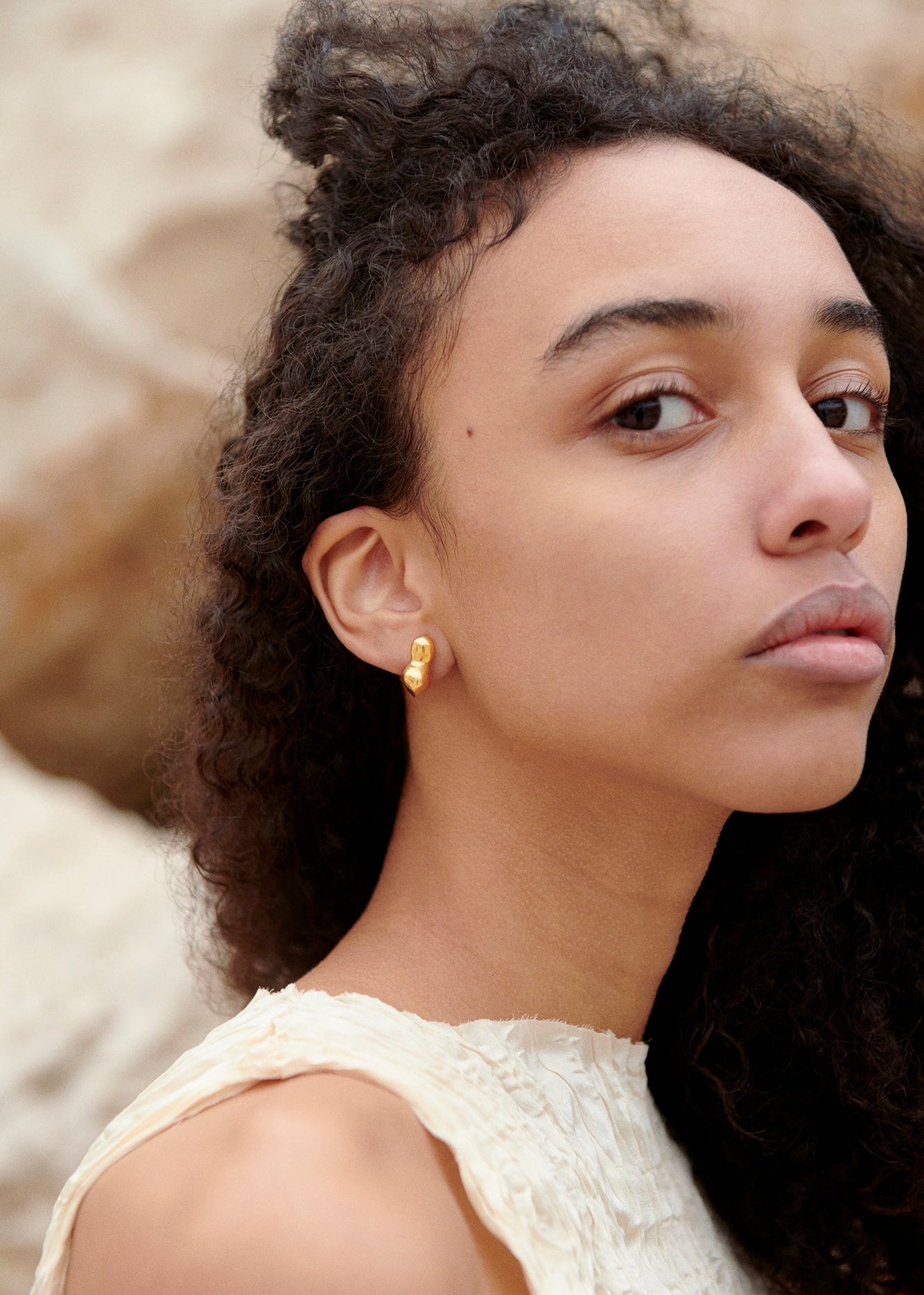 Woman wearing AGMES 18k gold vermeil sculpted small bubble hoop earrings. Simone Bodmer-Turner.