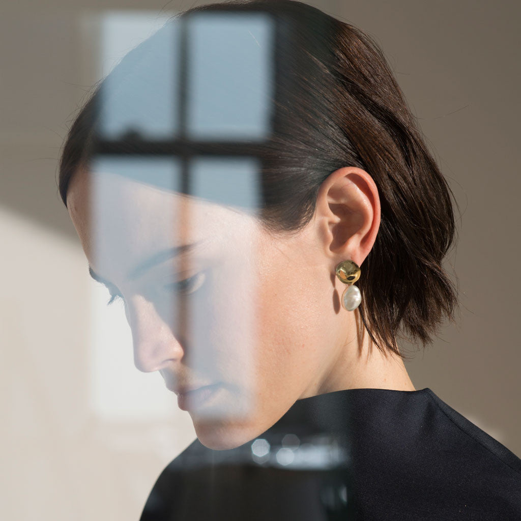 Woman wearing AGMES 18k gold vermeil small round earrings with freshwater pearl drop.