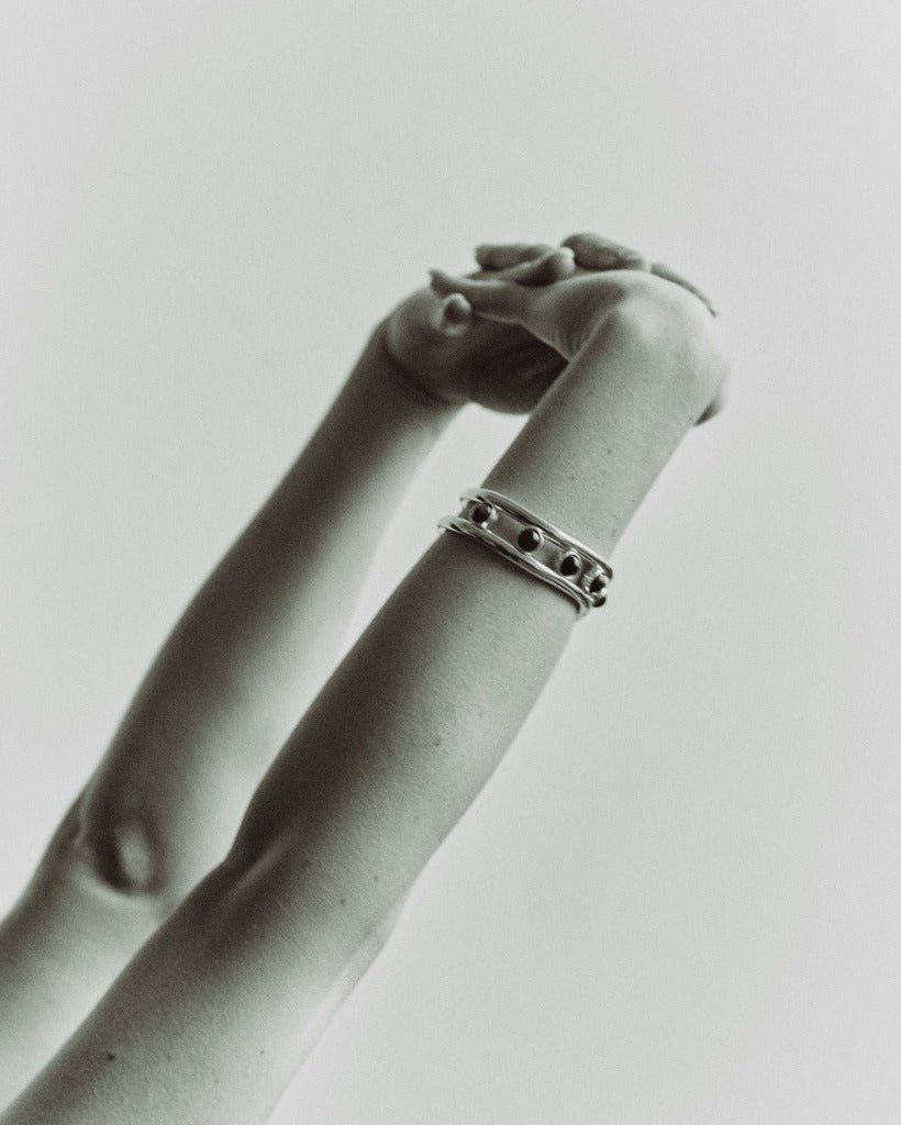Person wearing AGMES 0.925 sterling silver Cara cuff bracelet with lapis stone on white background.