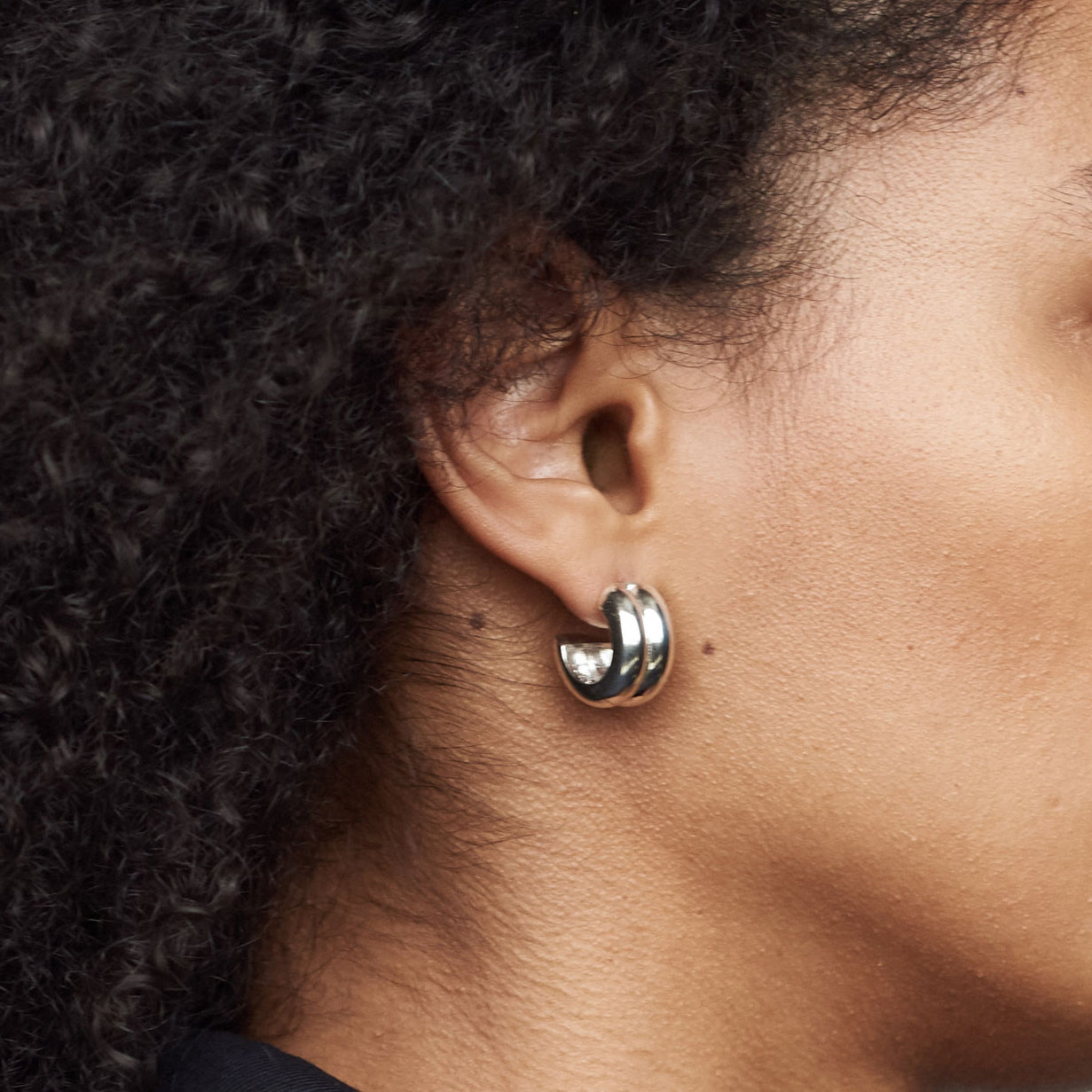 Person wearing AGMES 0.925 sterling silver double ridged small hoop earrings.