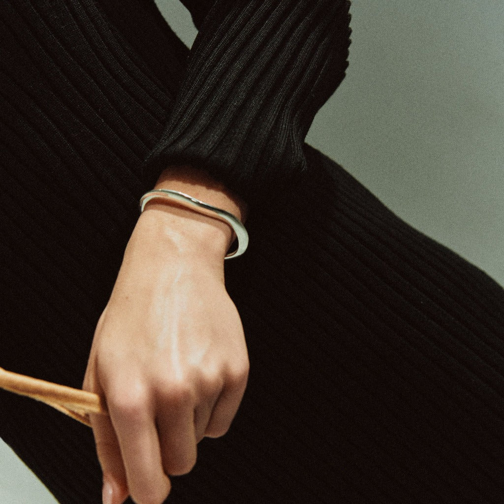 Woman wearing AGMES 0.925 sterling silver small thin sculpted cuff bracelet.