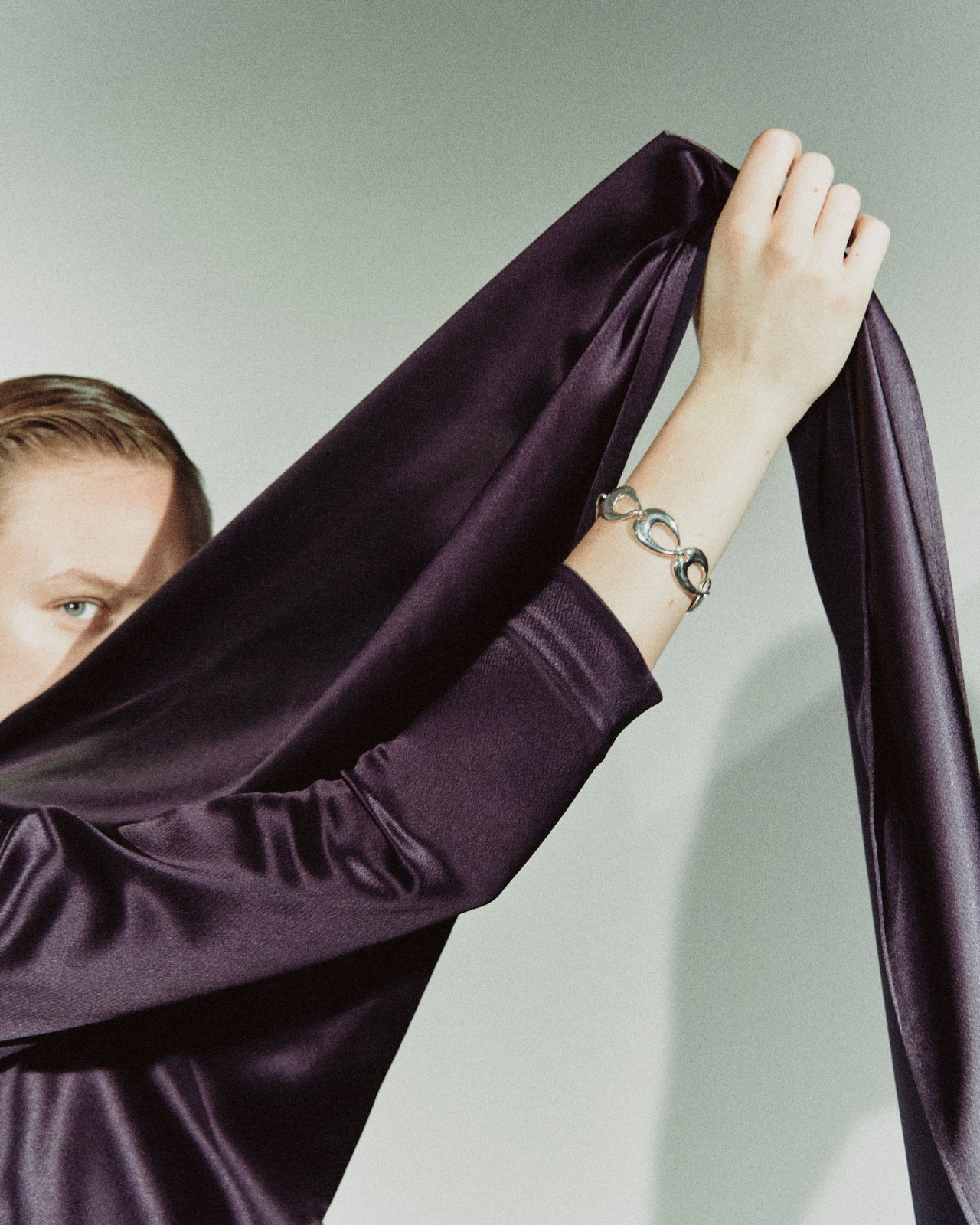 Model wearing AGMES .925 sterling silver sculptural link Tilda bracelet and dark purple blouse.