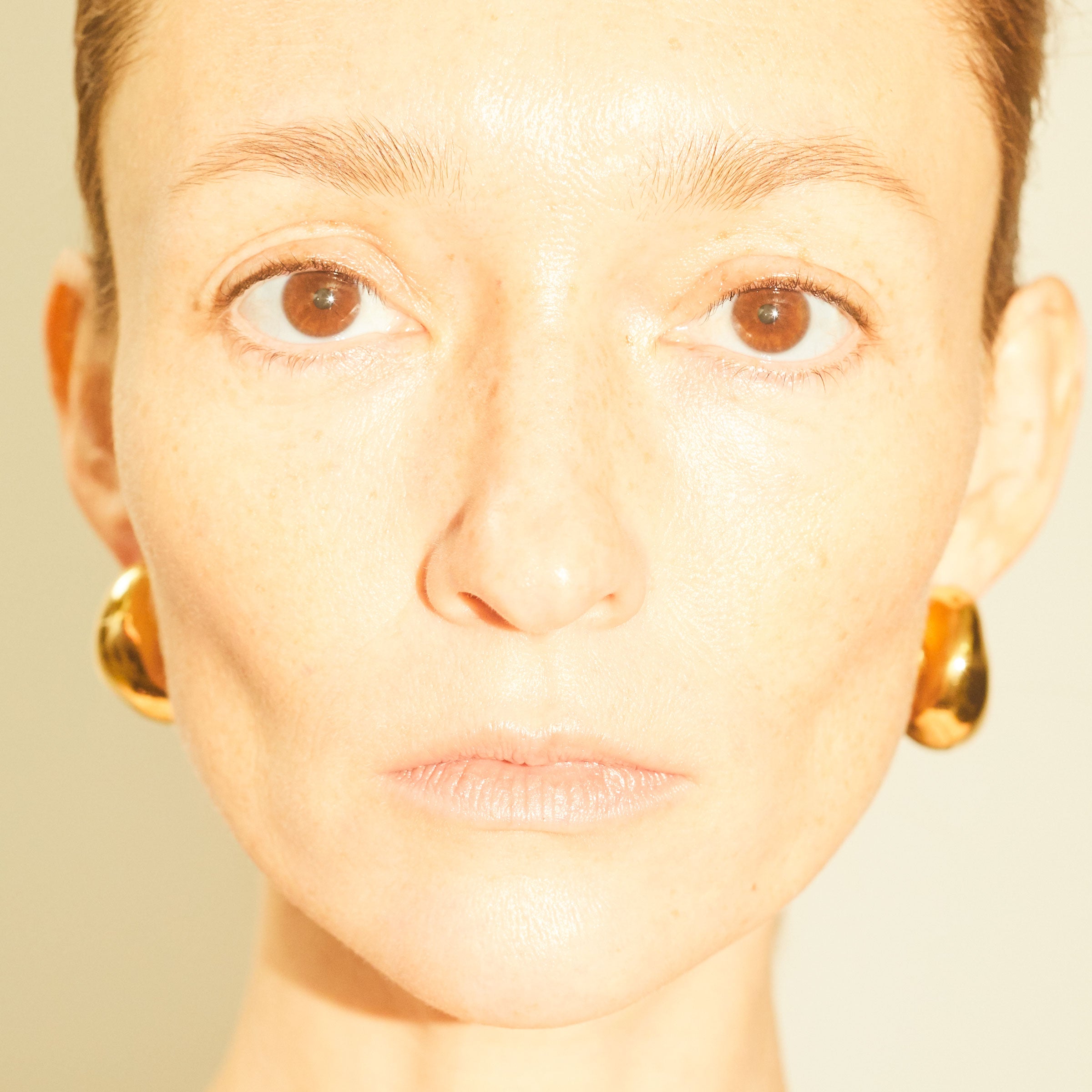 Woman wearing AGMES 18k gold vermeil medium hoop earrings.