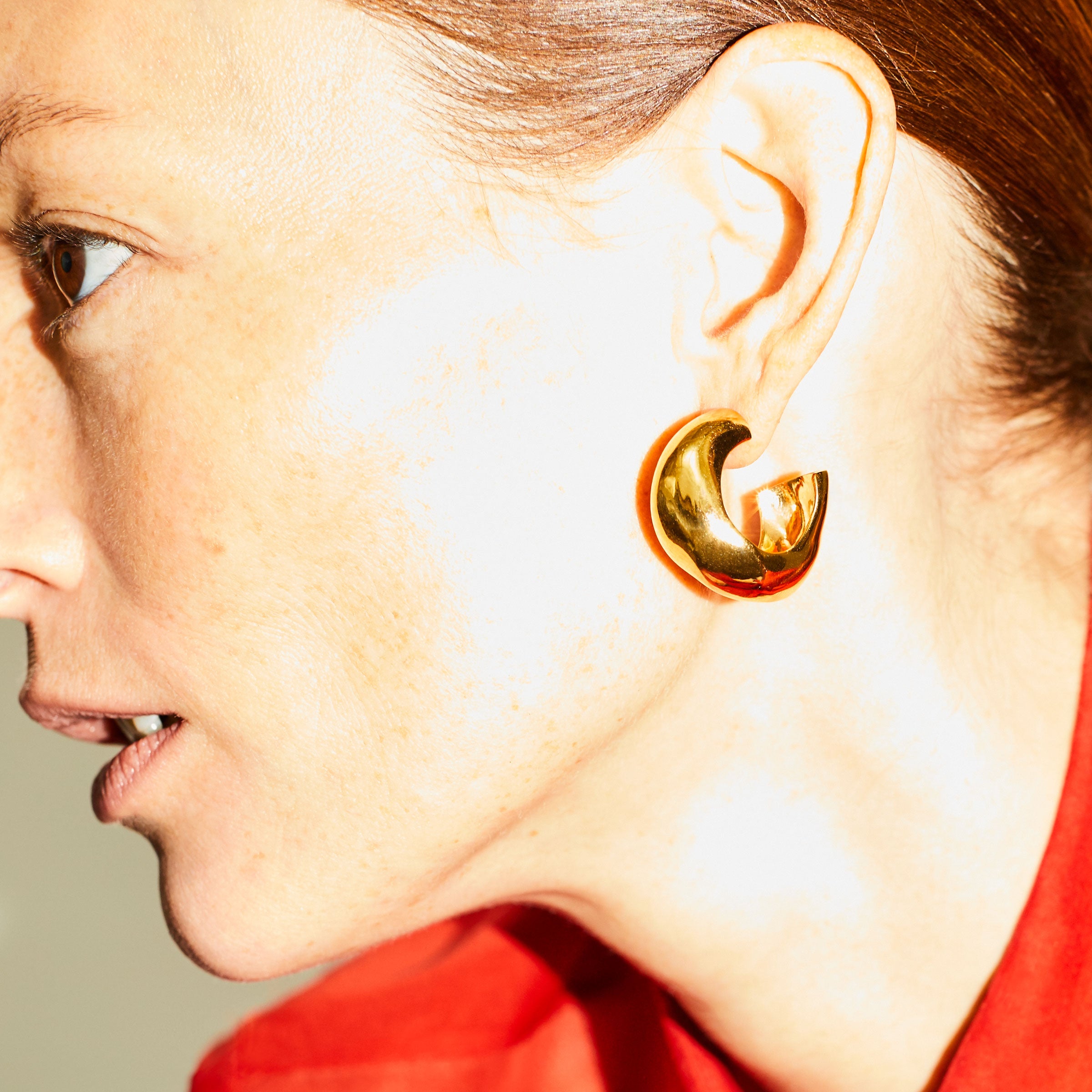Woman wearing AGMES 18k gold vermeil medium hoop earrings.