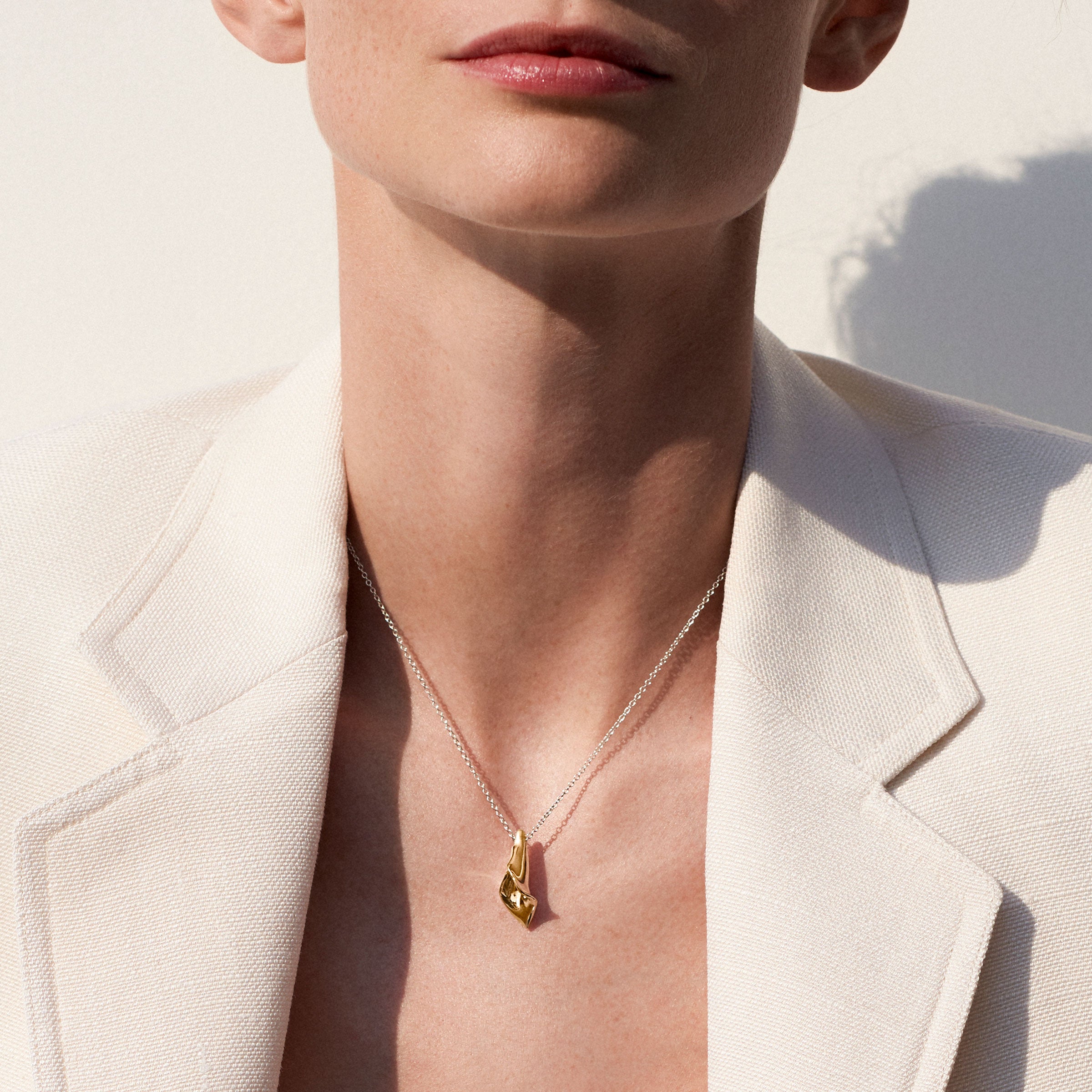 Person wearing AGMES 18K Gold Vermeil Modern Flower Mini Calla Pendant paired with Sterling Silver Chain necklace.