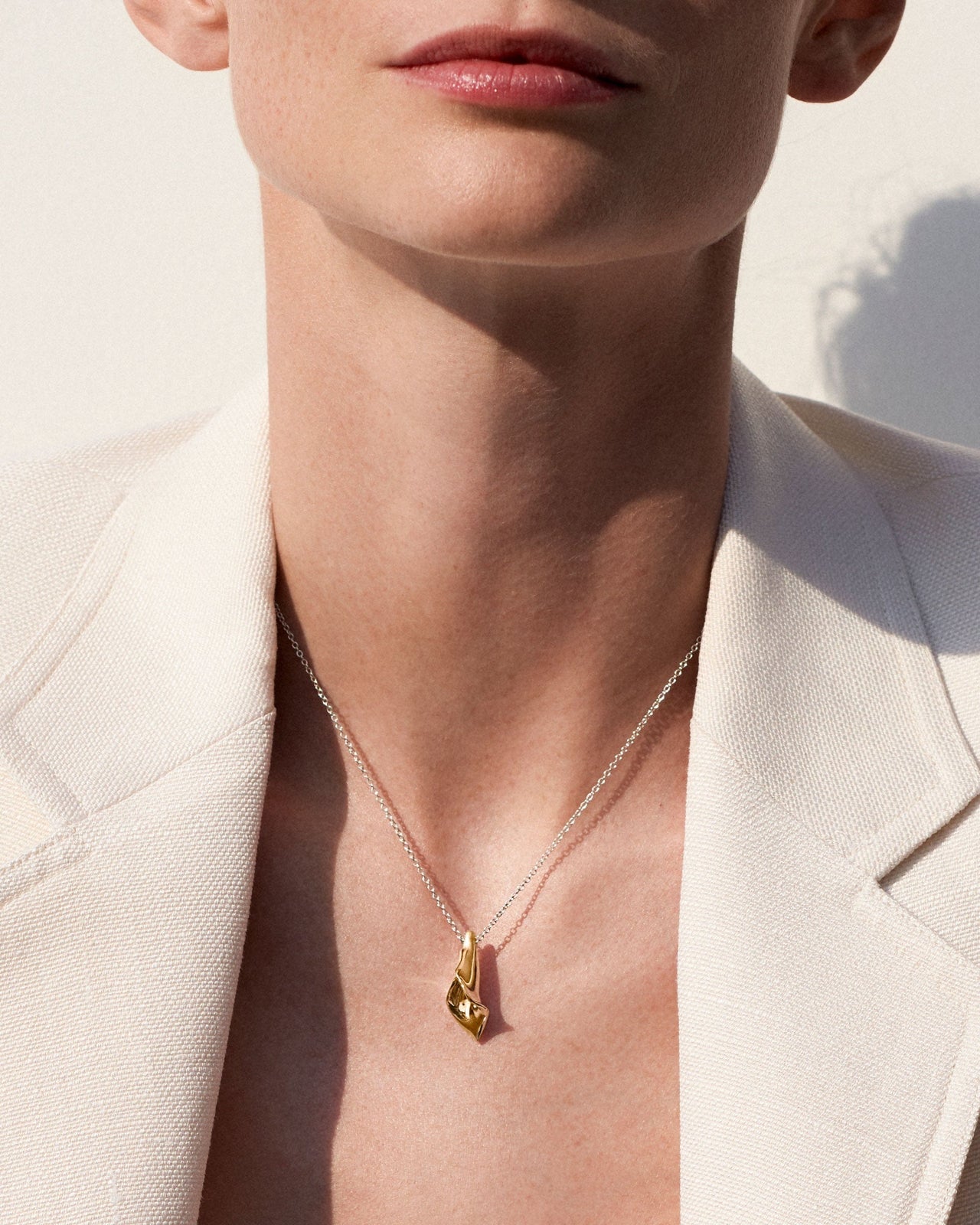 Person wearing AGMES 18K Gold Vermeil Modern Flower Mini Calla Pendant paired with Sterling Silver Chain necklace.