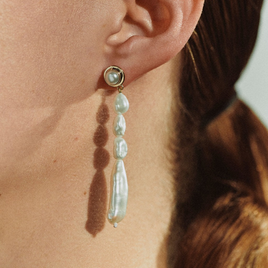 Woman wearing AGMES pearl drop earrings 18k gold vermeil.