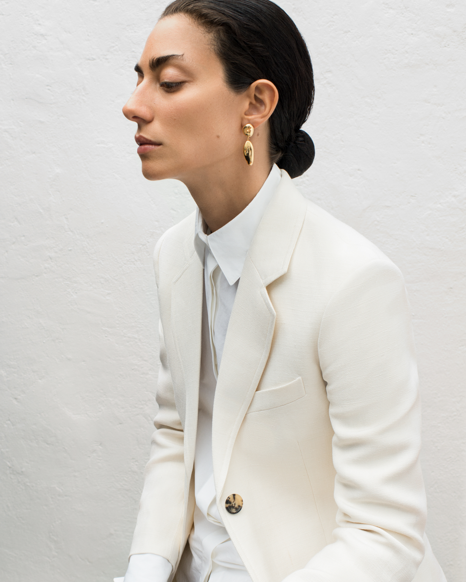 Woman wearing AGMES 18k gold vermeil sculpted drop earrings.