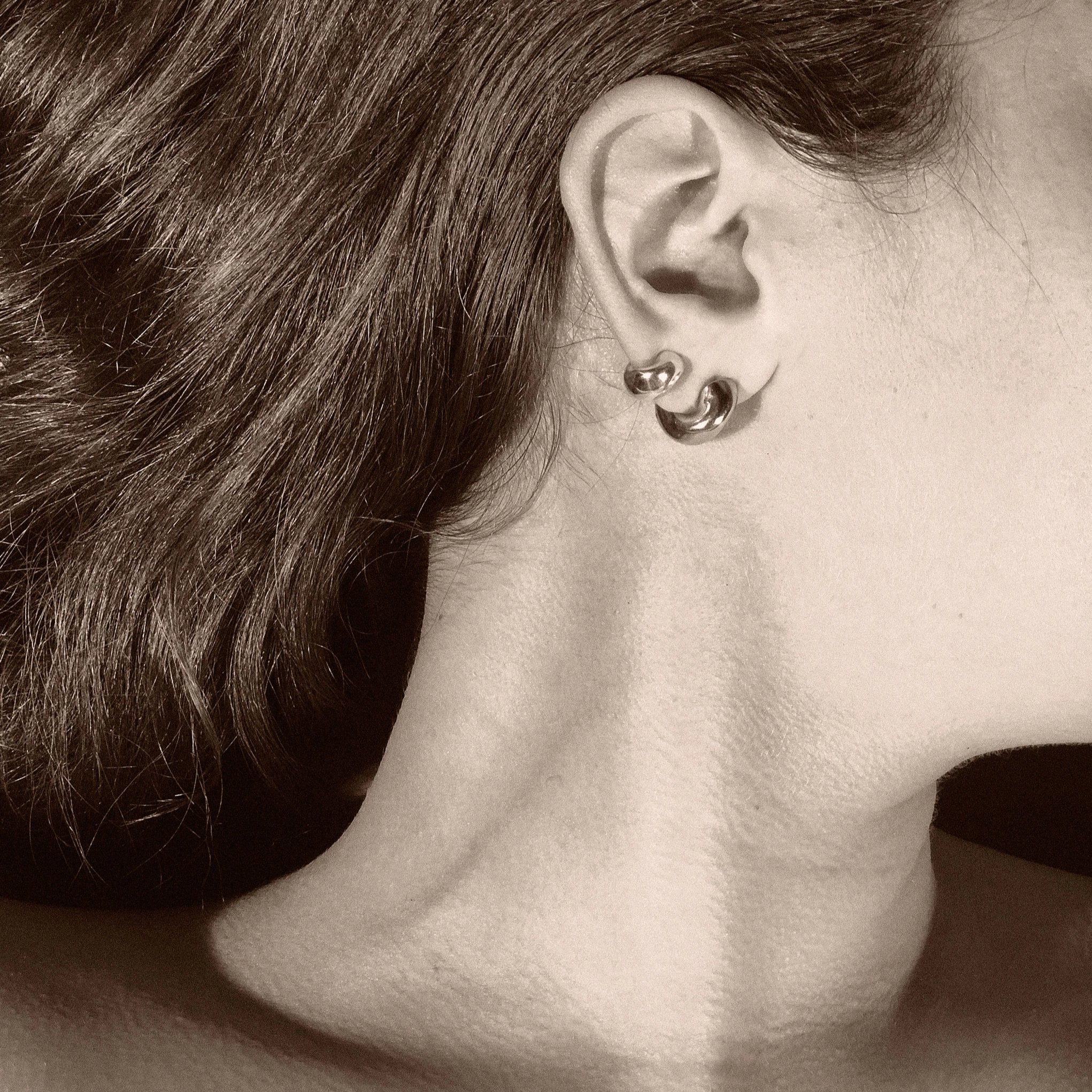 Woman wearing AGMES 18k gold vermeil thick hoop earrings.