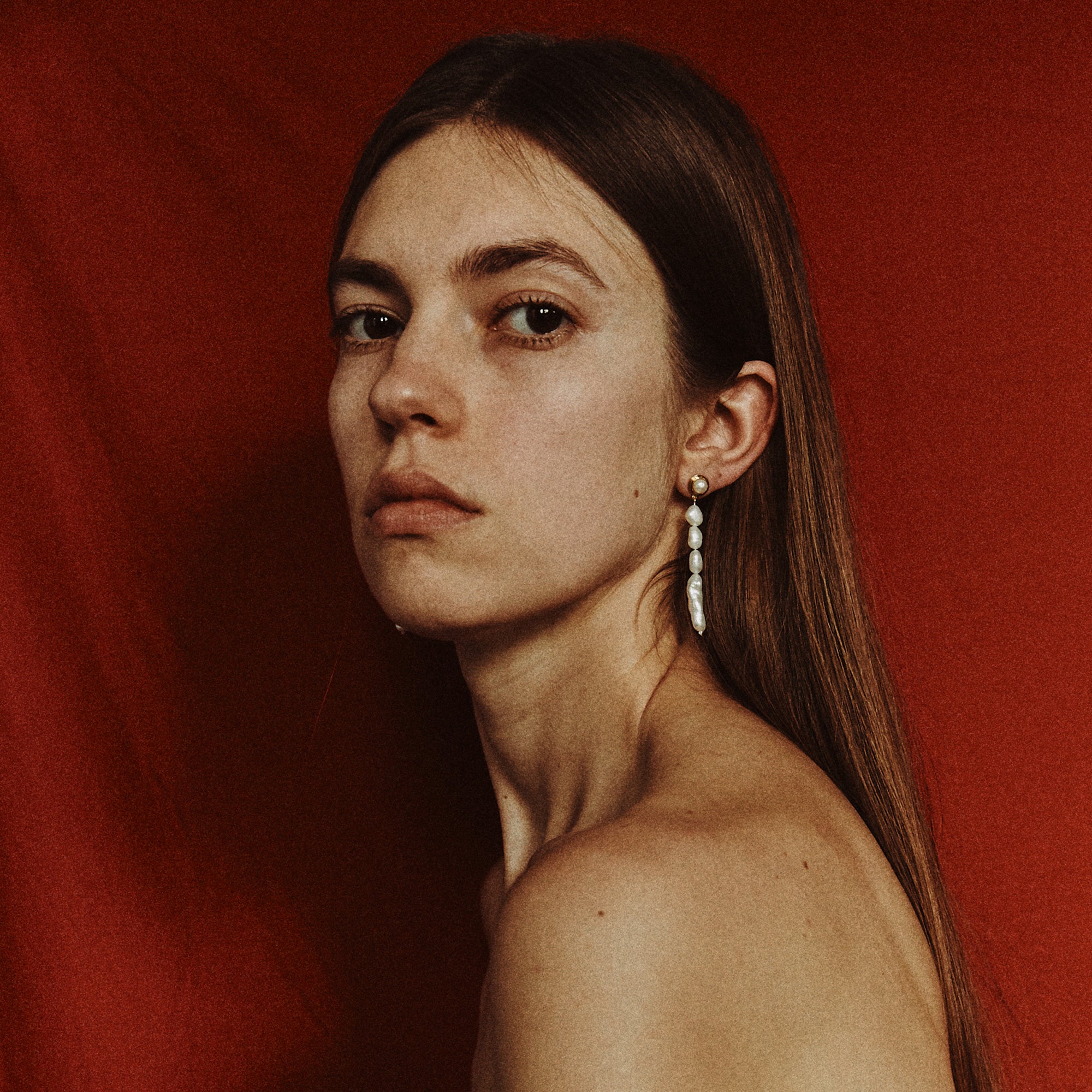 Woman wearing AGMES pearl drop earrings 18k gold vermeil.