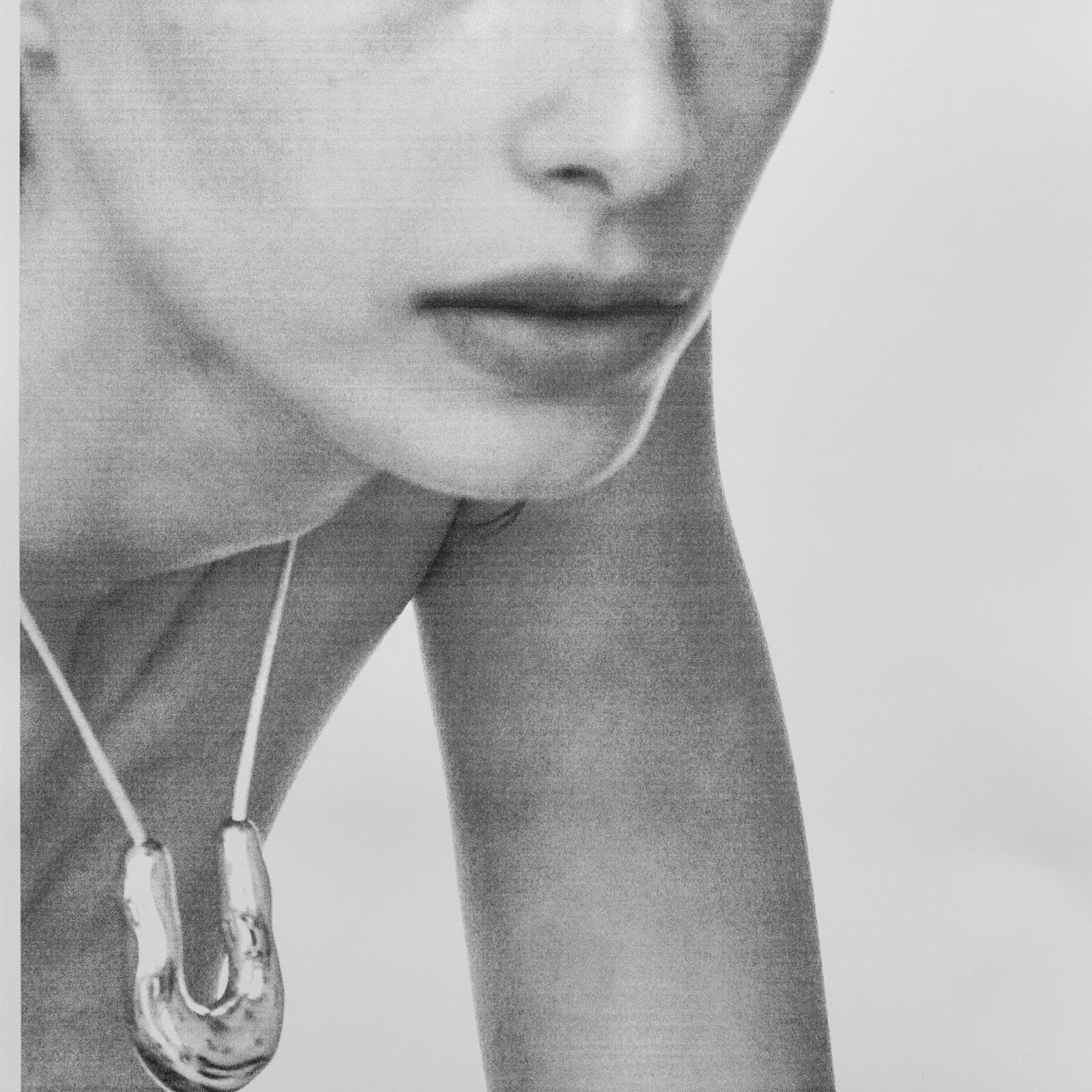 Person wearing AGMES .925 sterling silver wishbone pendant on Ivory Satin cord.