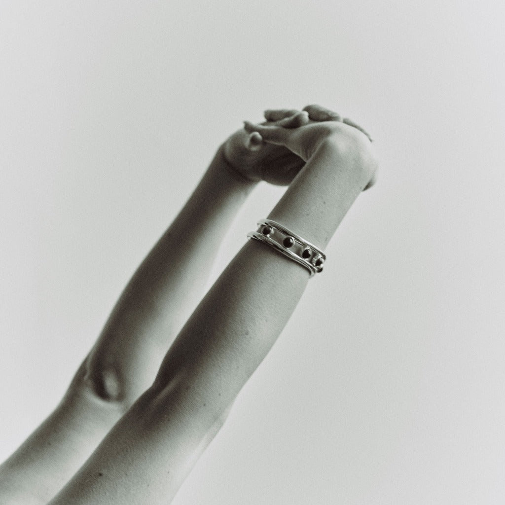 Person wearing AGMES 0.925 sterling silver Cara cuff bracelet with lapis stone on white background.