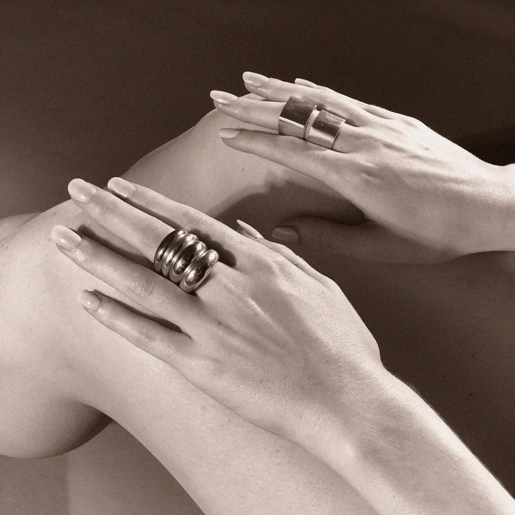 Hands wearing AGMES .925 Sterling Silver Thin Domed Ring and Daria Ring.