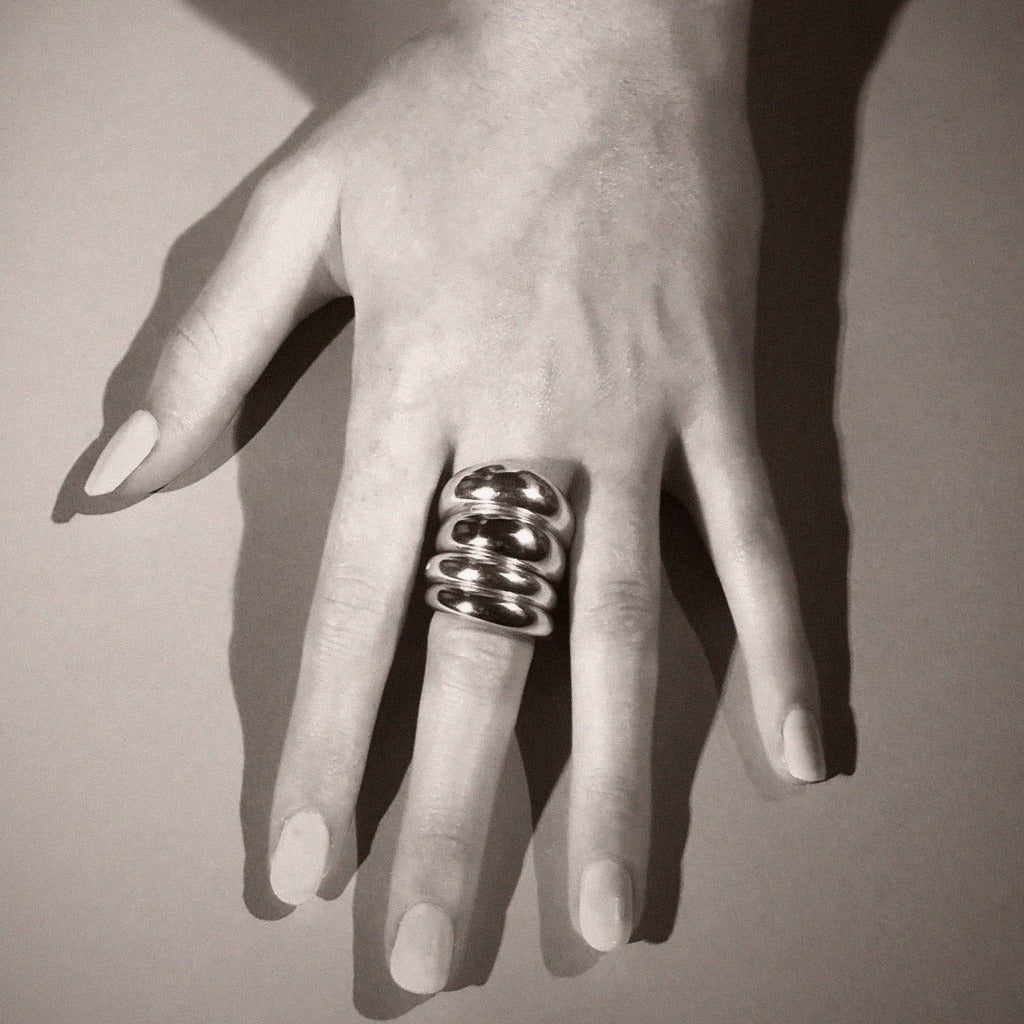 Hand wearing multiple AGMES .925 Sterling Silver Thin Domed Rings.