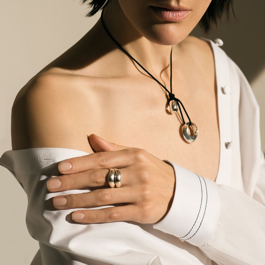 Woman wearing AGMES .925 Sterling Silver Double Wave Ring and Rae Pendant.