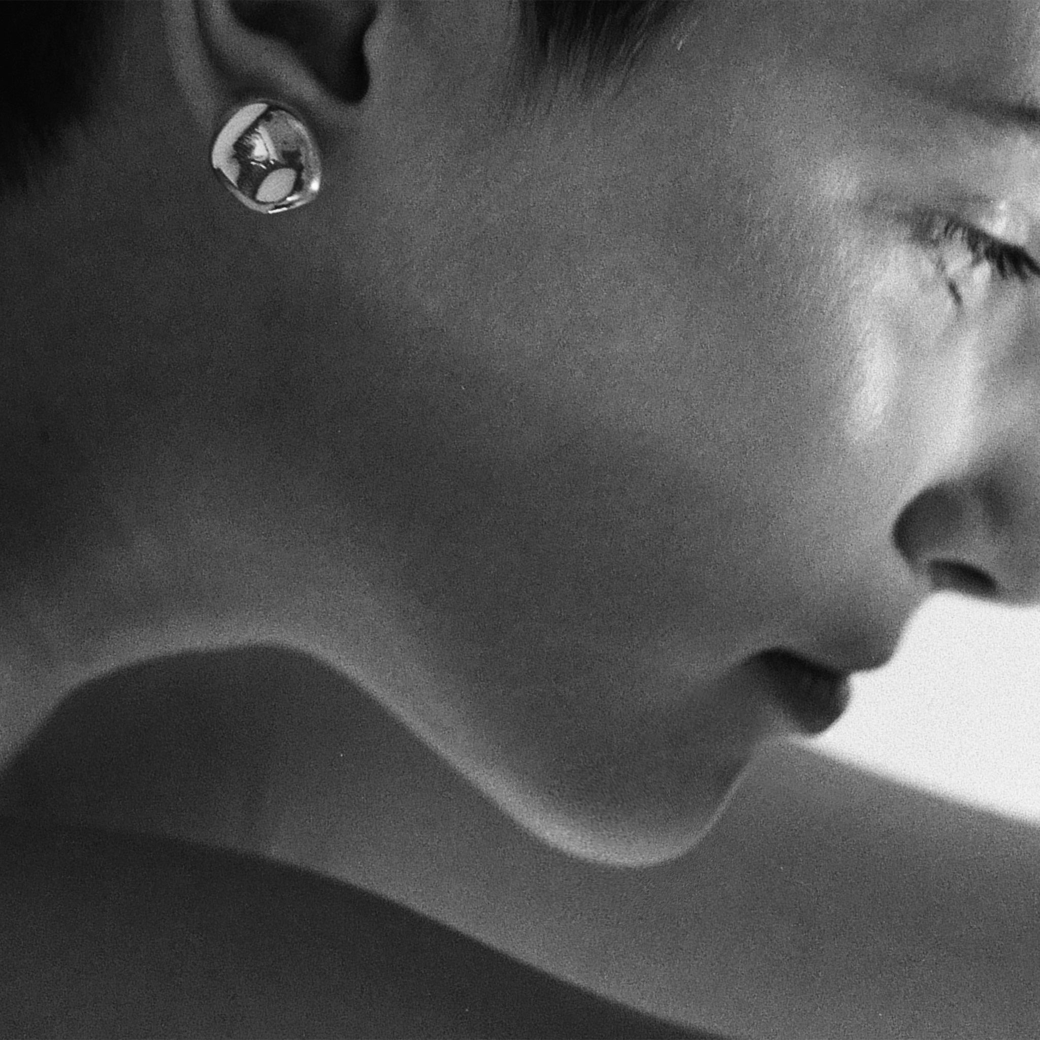 Woman wearing AGMES 18k gold vermeil sculpted round stud earrings.