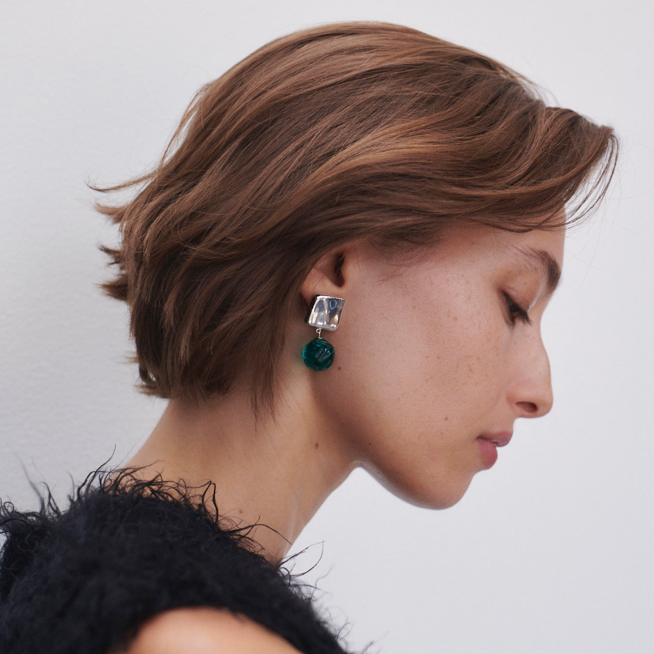 Woman wearing AGMES 0.925 sterling silver Lea Earrings with green glass beads.