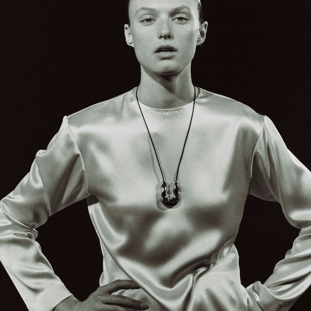 Woman wearing AGMES 0.925 Sterling Silver Large Wishbone Pendant on Black Suede Cord.