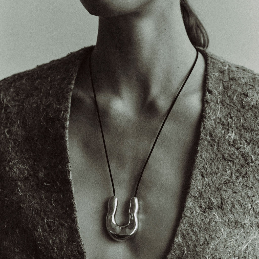 Woman wearing AGMES 0.925 Sterling Silver Large Wishbone Pendant on Black Suede Cord.