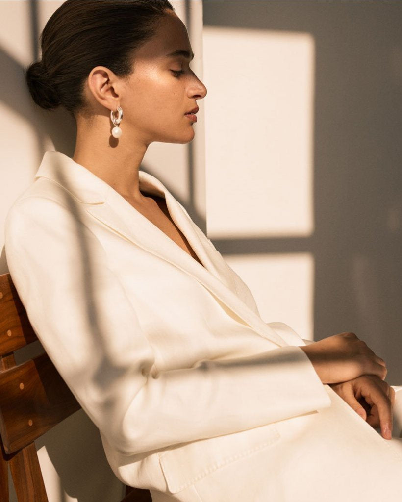 Woman wearing AGMES 0.925 sterling silver hinged hoop earrings with freshwater pearl drop embellishments.