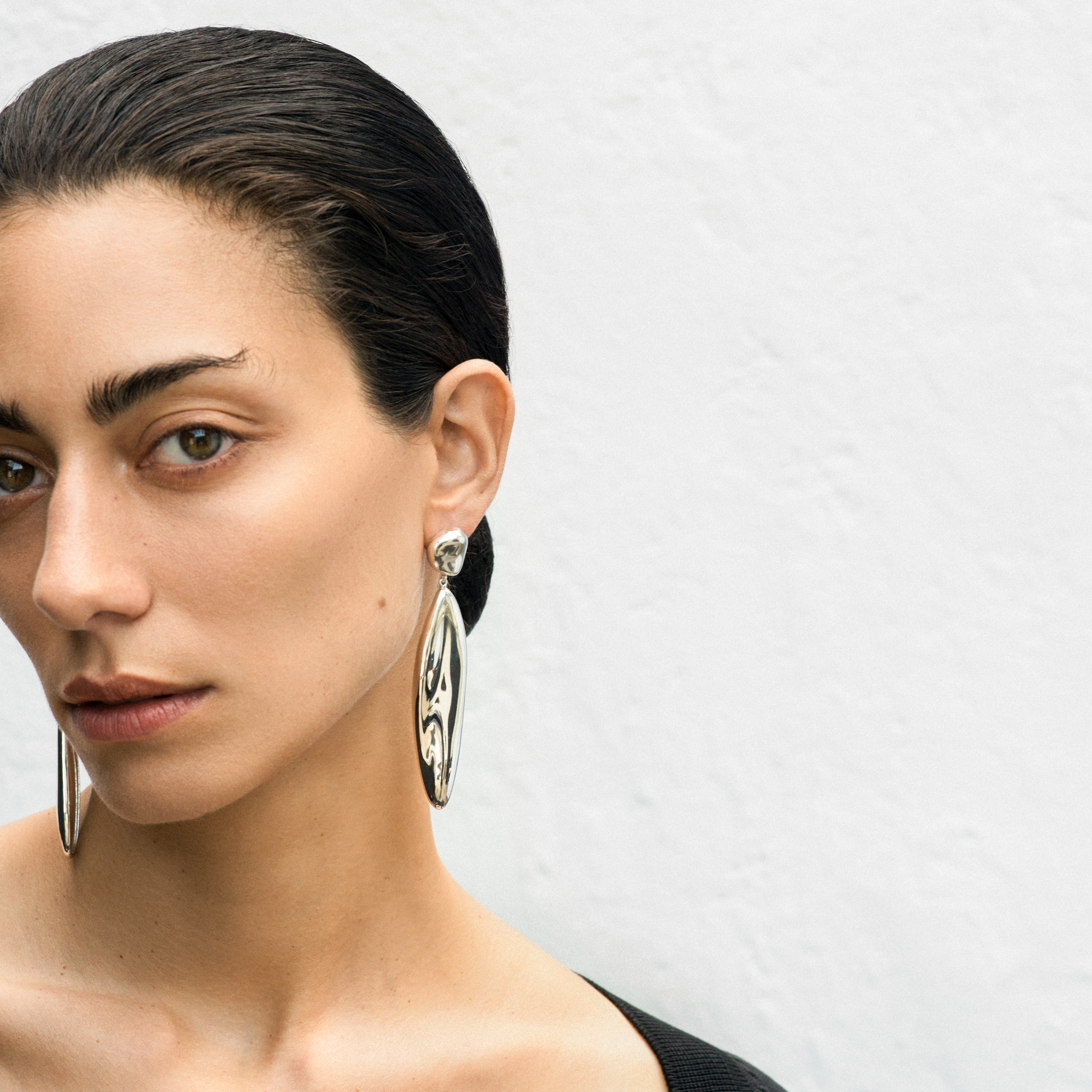 Woman wearing AGMES 0.925 sterling silver sculpted drop earrings.