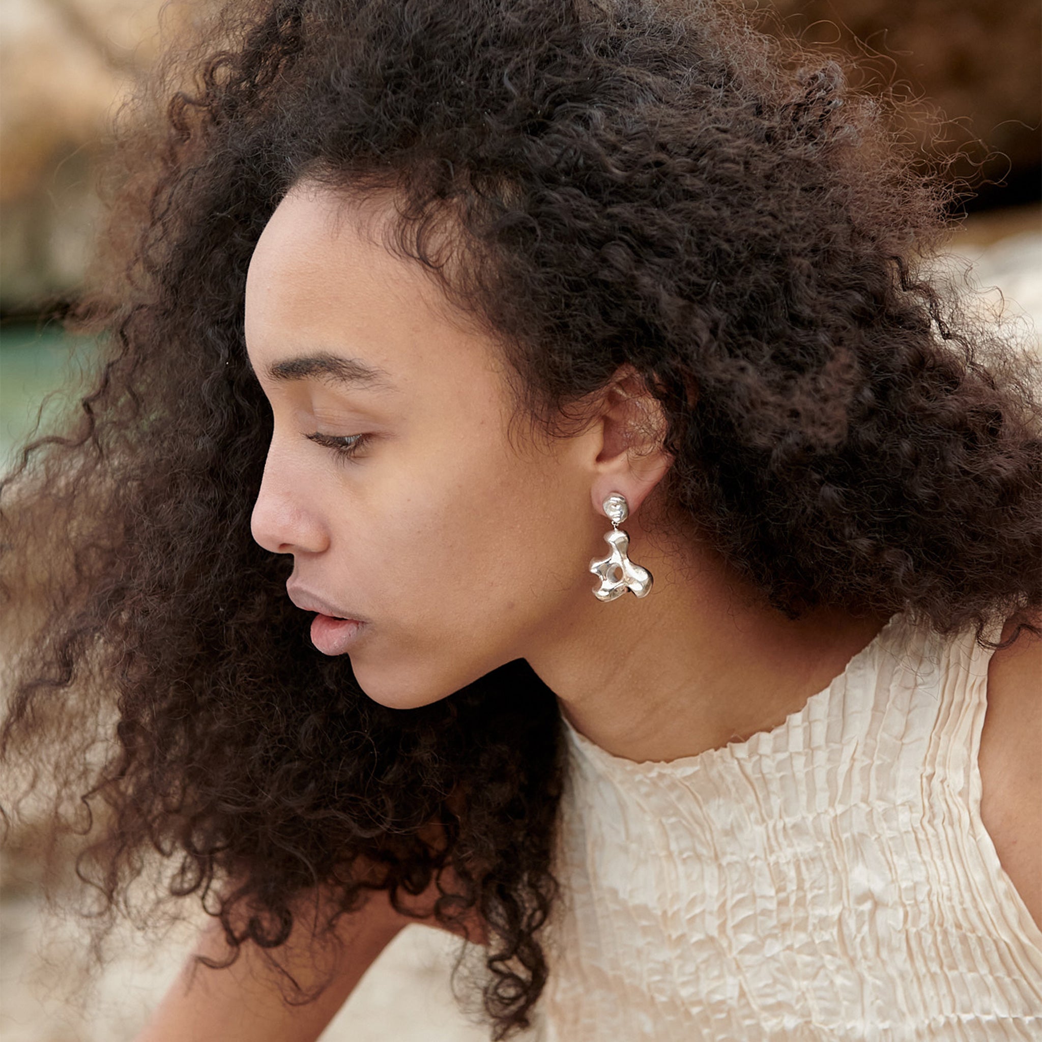 Woman wearing AGMES 0.925 sterling silver sculpted drop earrings. Simone Bodmer-Turner.
